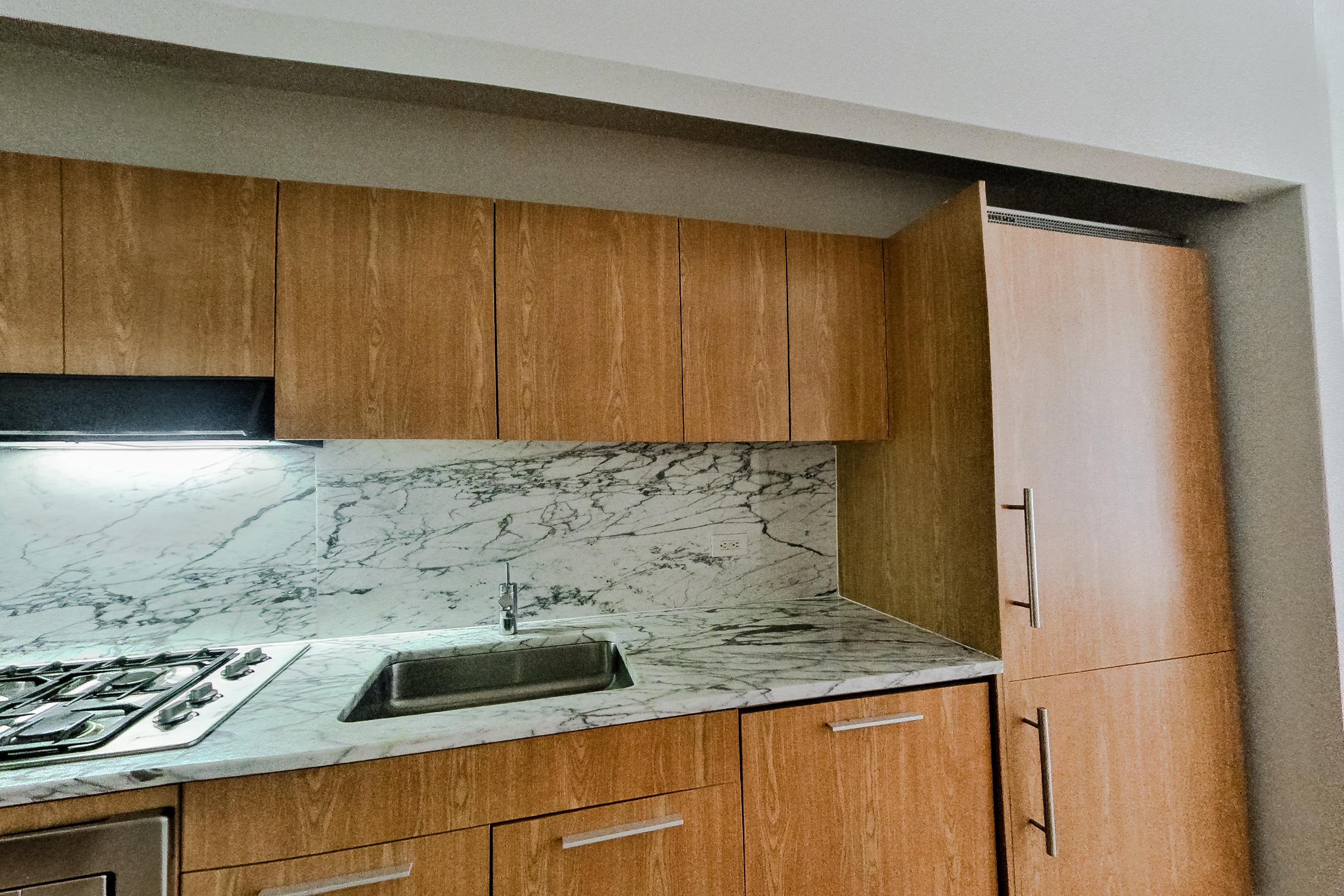 Kitchen with cooktop, dark wood-finish flooring, gas cooktop, light stone countertops, light wood-finish flooring, and stainless steel appliances, Apartment 1805 at Platinum Properties