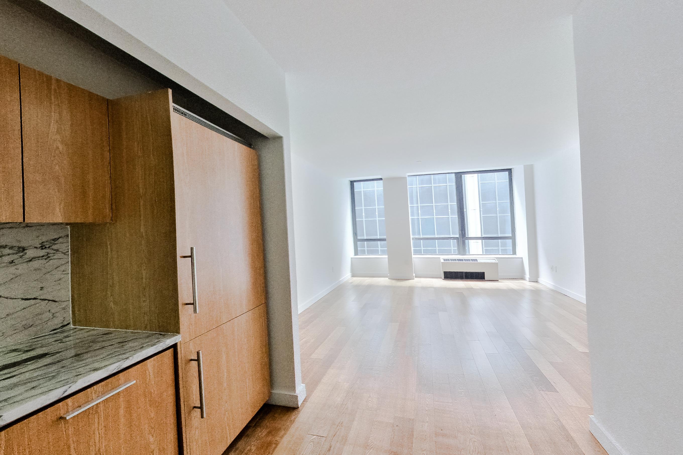 Kitchen with cooktop, dark wood-finish flooring, gas cooktop, light stone countertops, light wood-finish flooring, and stainless steel appliances, Apartment 1805 at Platinum Properties