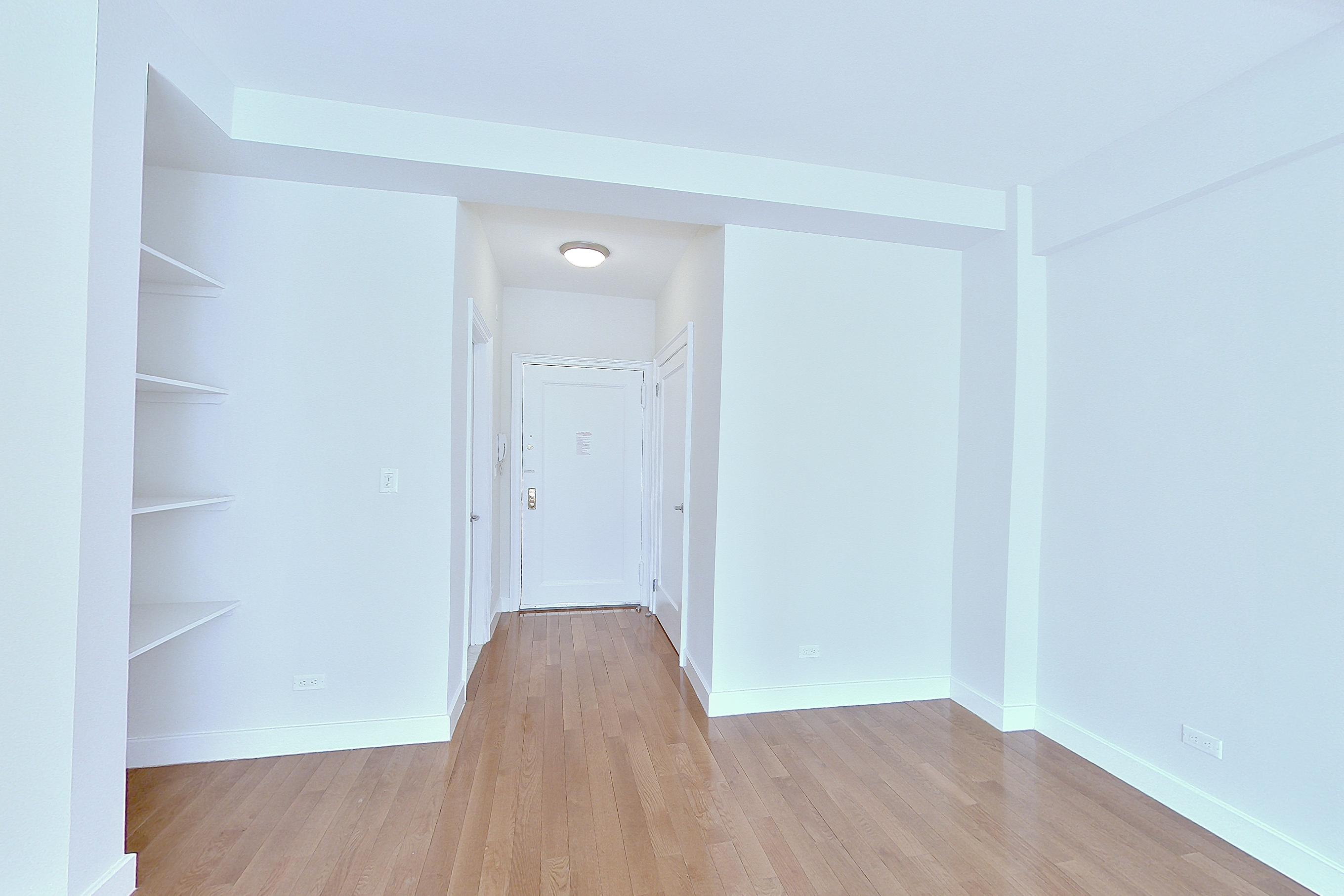 Living area with light wood-finish flooring, Apartment 16D at Stonehenge Leasing