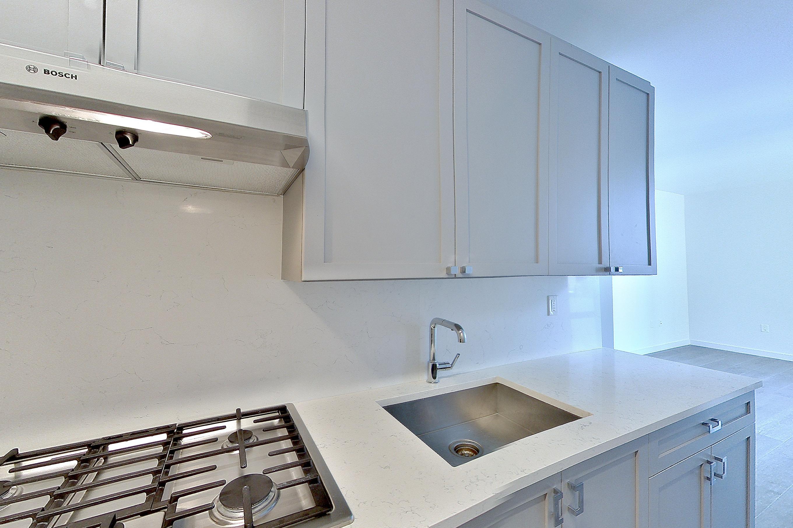 Kitchen with cooktop, gas cooktop, light stone countertops, oven/range, and stainless steel appliances, Apartment 1601 at 1 Flatbush