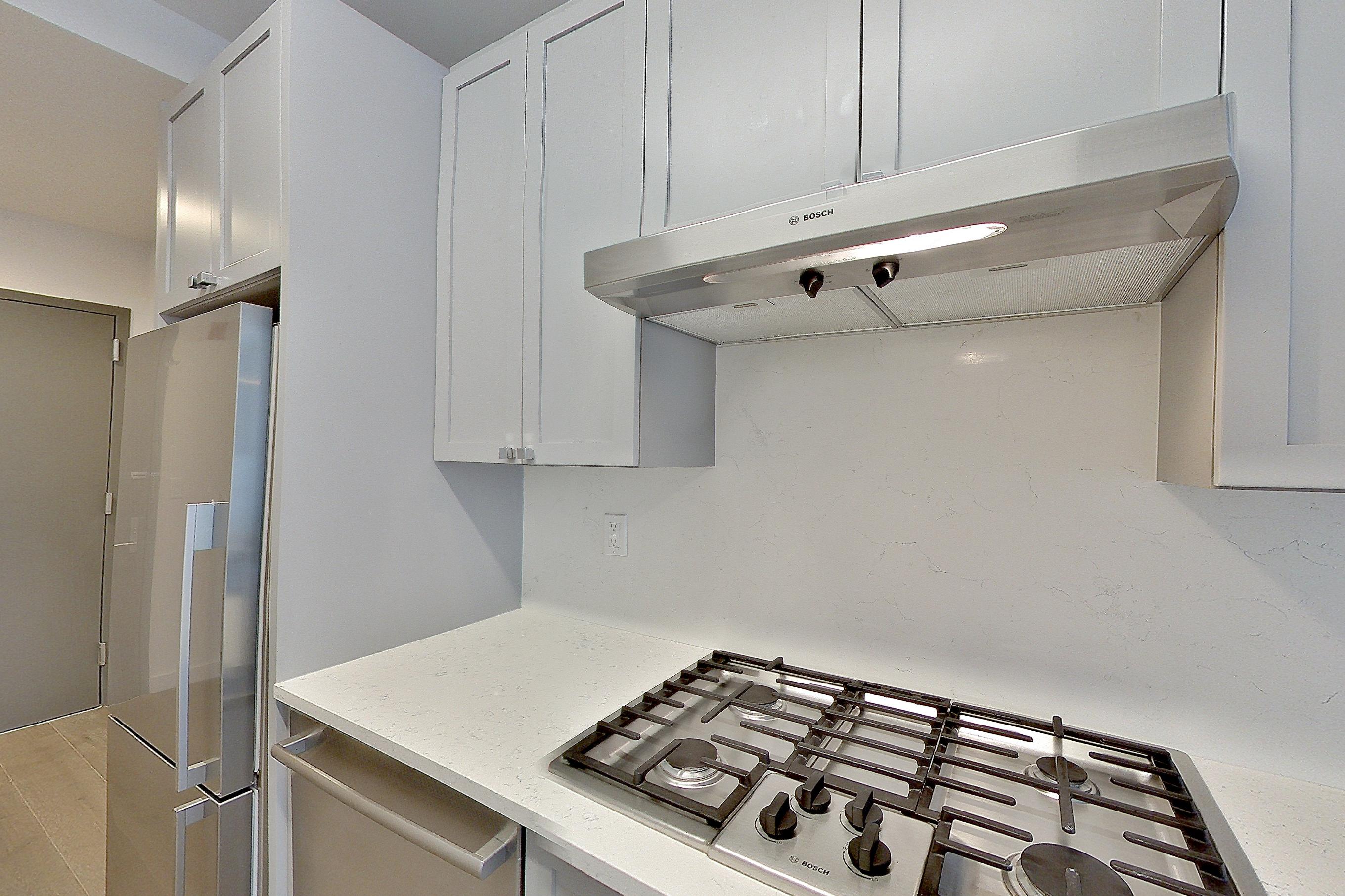 Kitchen with cooktop, gas cooktop, light stone countertops, oven/range, and stainless steel appliances, Apartment 1601 at 1 Flatbush