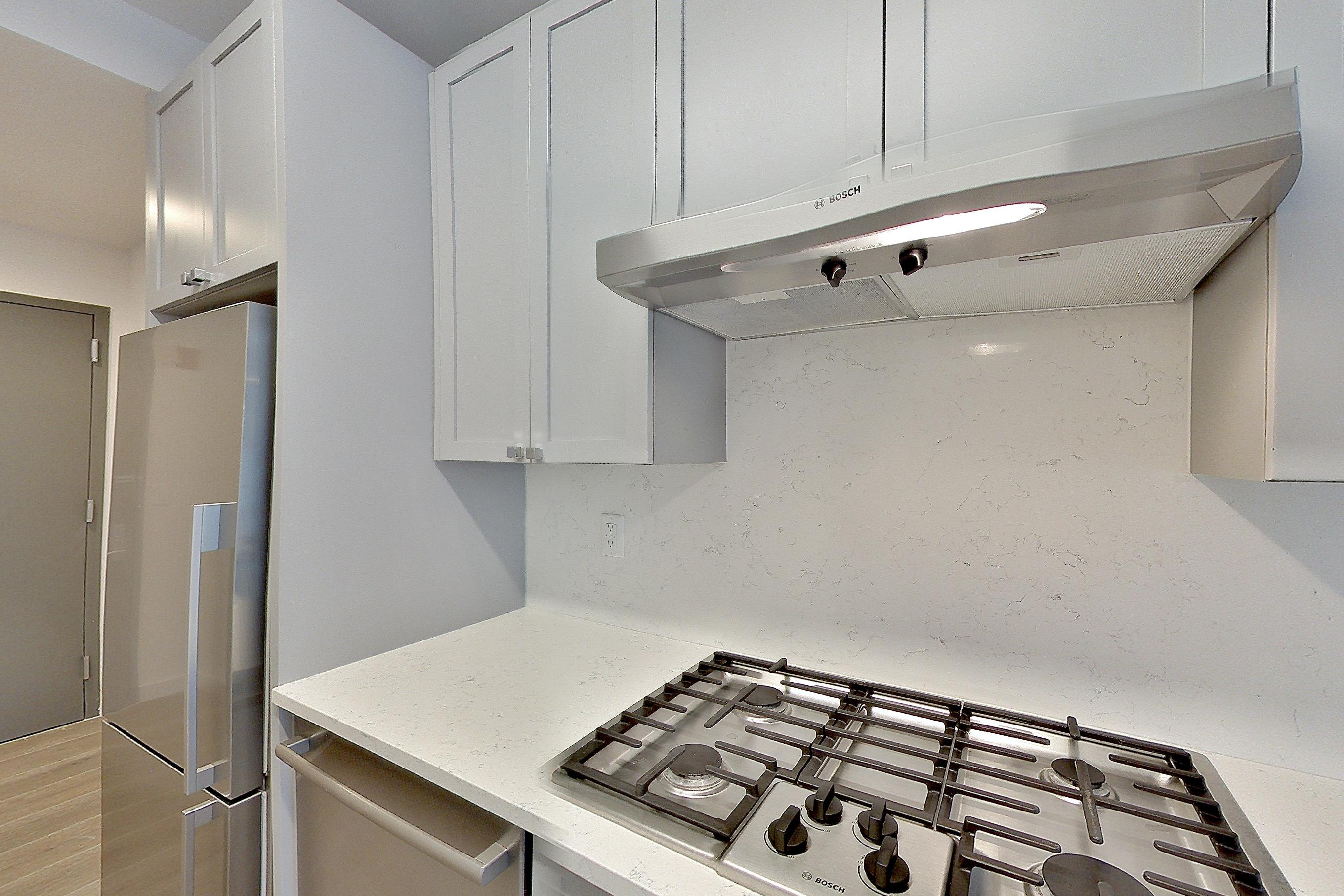 Kitchen with cooktop, gas cooktop, light stone countertops, oven/range, and stainless steel appliances, Apartment 1501 at 1 Flatbush
