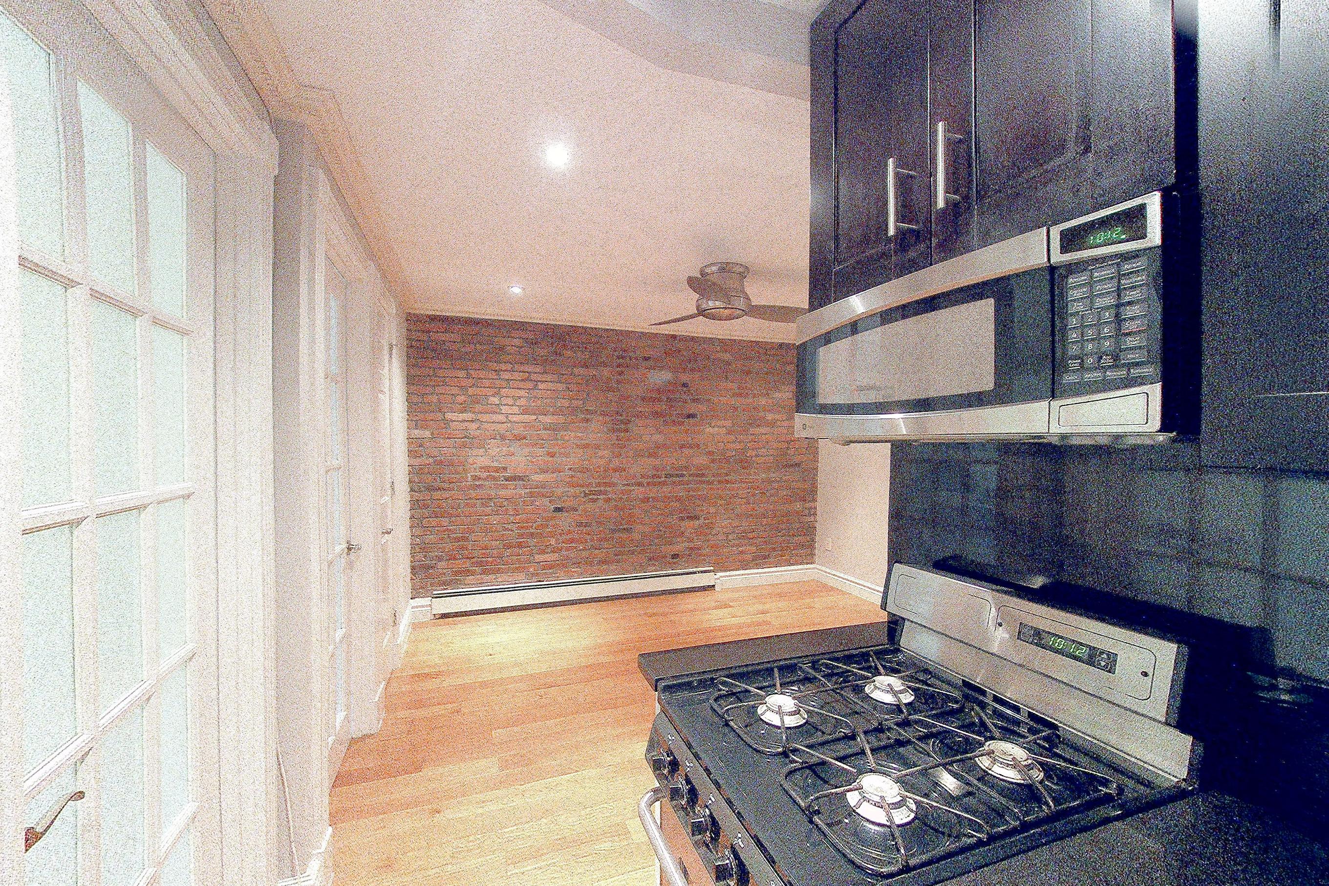 Kitchen with baseboard heating, gas range, oven/range, and stainless steel appliances, Apartment 3 at Centennial Properties