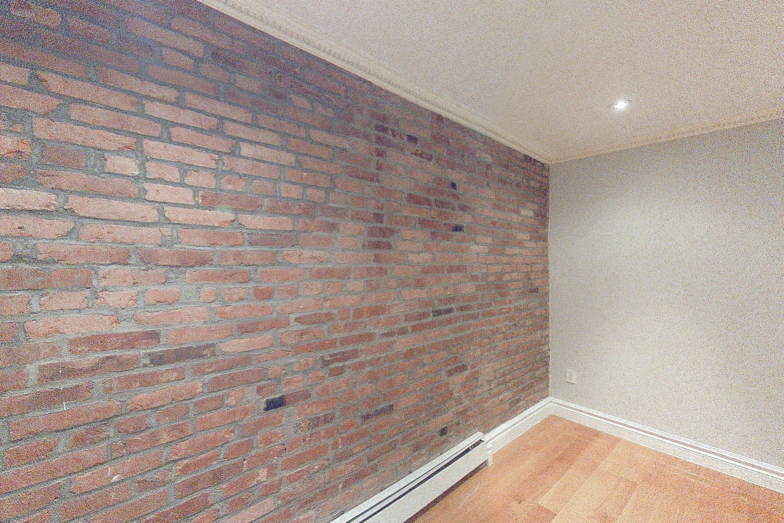 Living room closet with baseboard heating and brick-look tile flooring, Apartment 3 at Centennial Properties