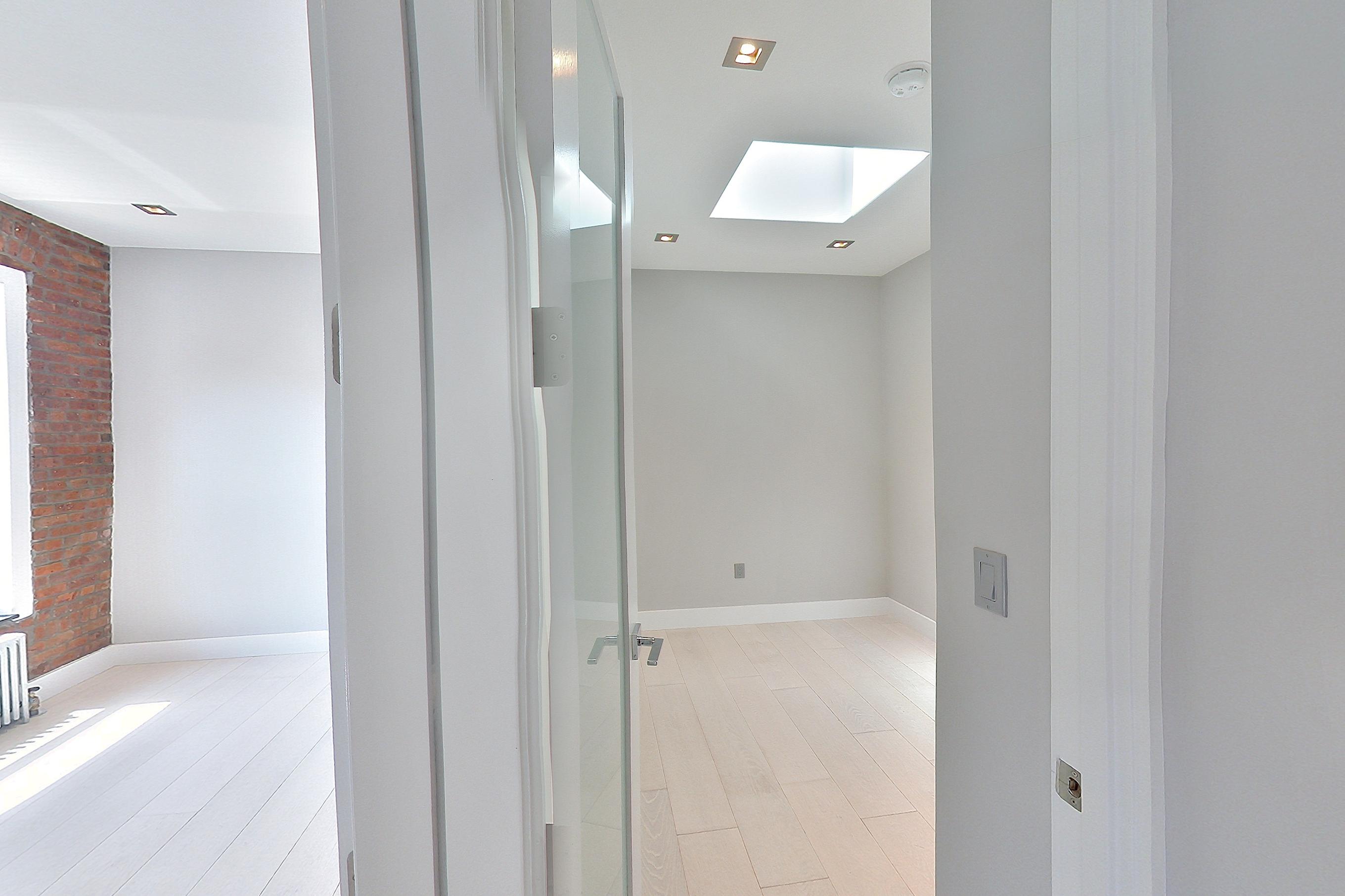 Kitchen with gas range, light wood-finish flooring, oven/range, radiator heat, and stainless steel appliances, Apartment 4 E at Centennial Properties