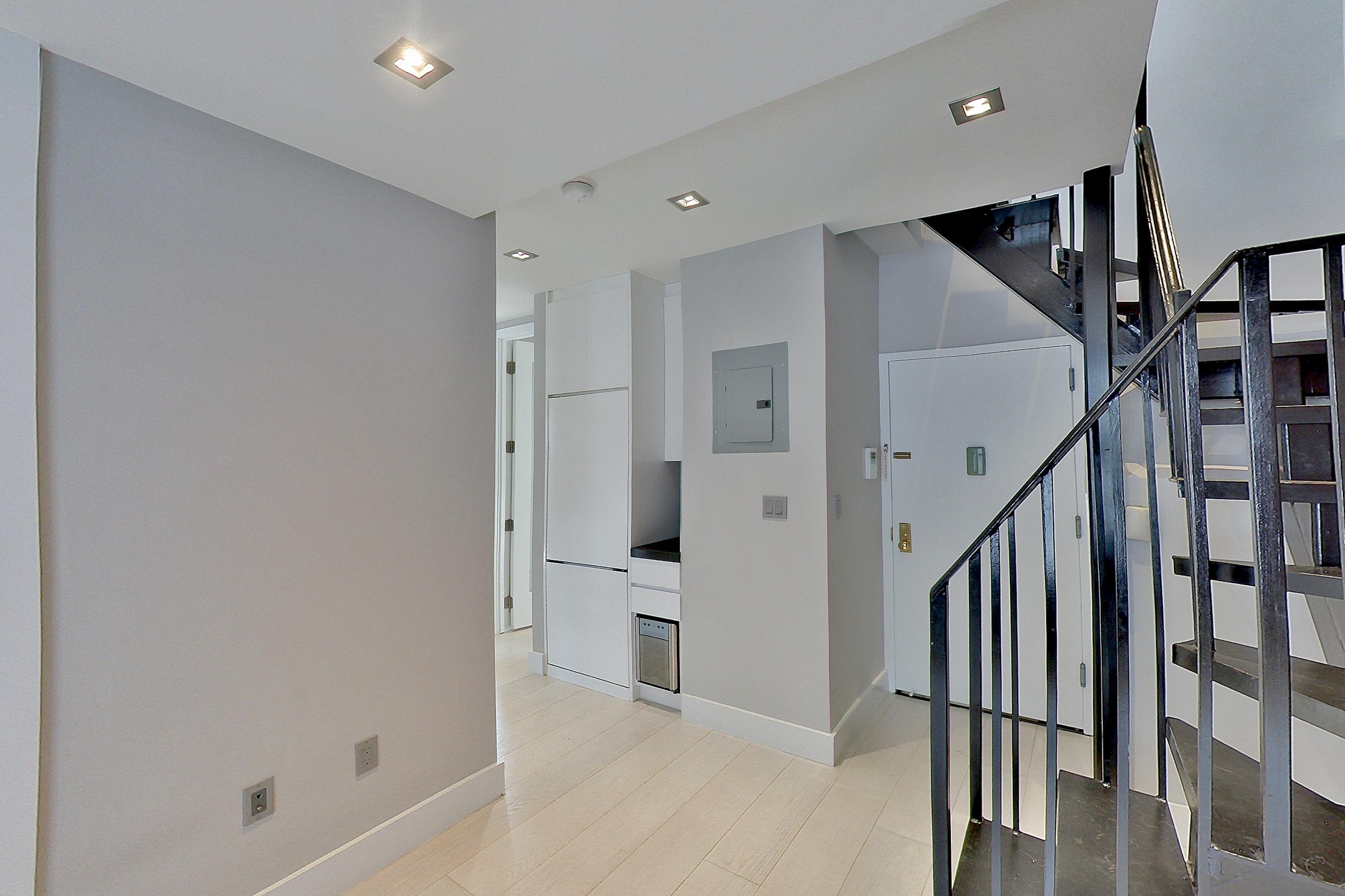 Living room with light wood-finish flooring and radiator heat, Apartment 4 E at Centennial Properties