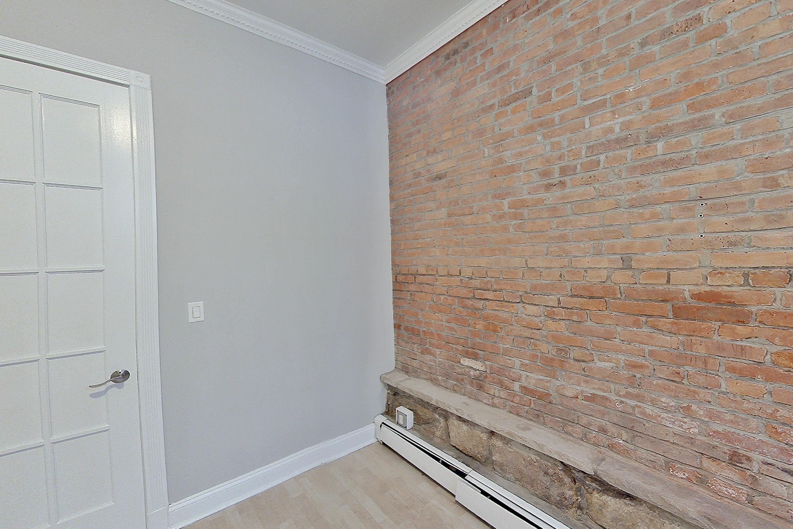 Living room with baseboard heating, brick-look tile flooring, light vinyl flooring, and light wood-finish flooring, Apartment LW at Centennial Properties