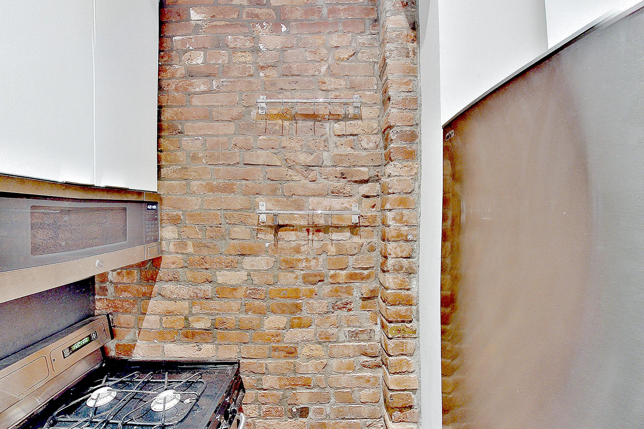 Kitchen with brick-look tile flooring, gas range, oven/range, and stainless steel appliances, Apartment B at Centennial Properties