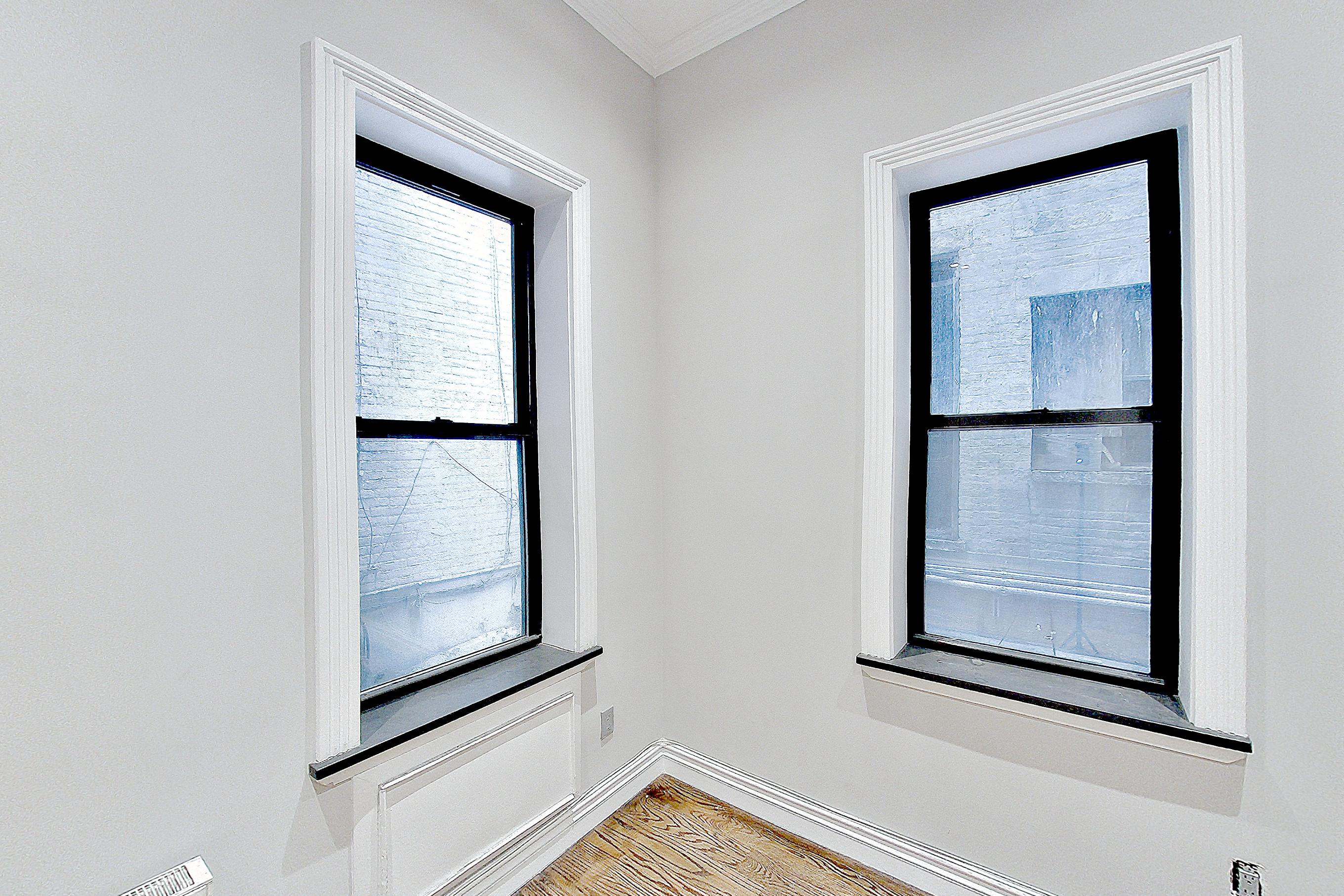 Living room with light wood-finish flooring, Apartment B at Centennial Properties