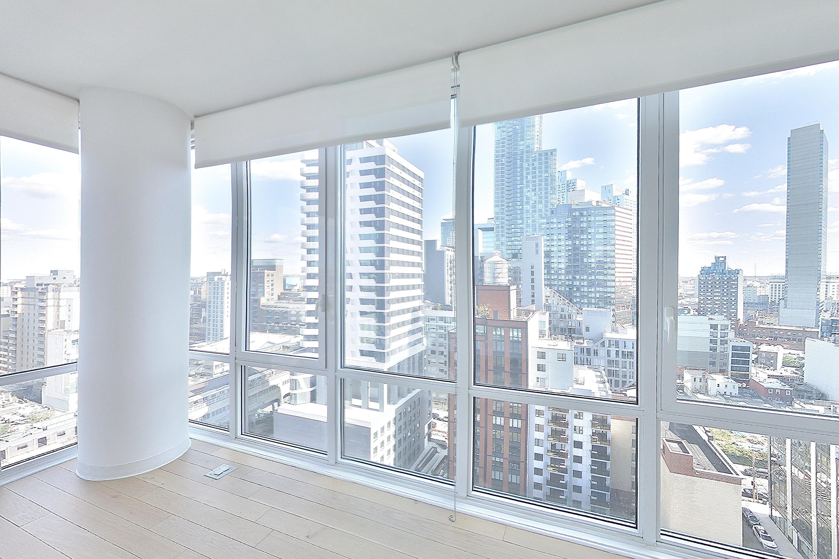 Living room with city view and light wood-finish flooring, Apartment 10-20J at Stonehenge Leasing