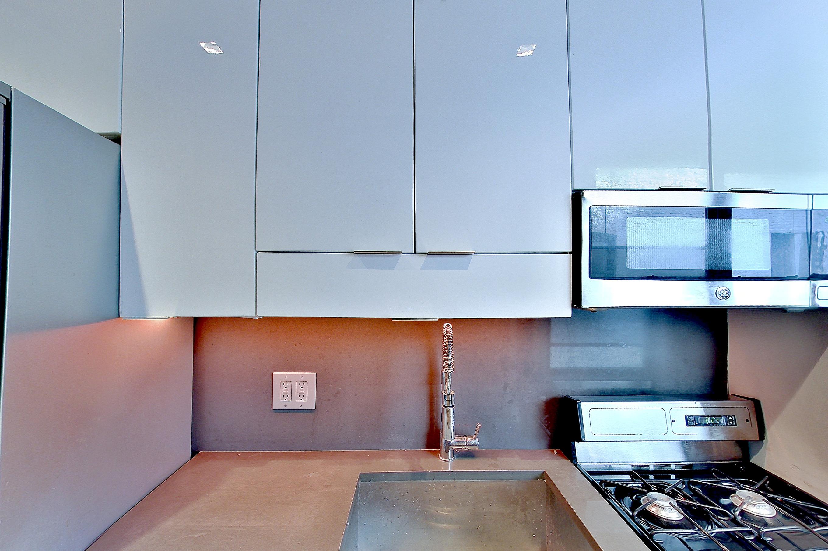 Kitchen with gas range, light wood-finish flooring, oven/range, radiator heat, and stainless steel appliances, Apartment 2F at Centennial Properties