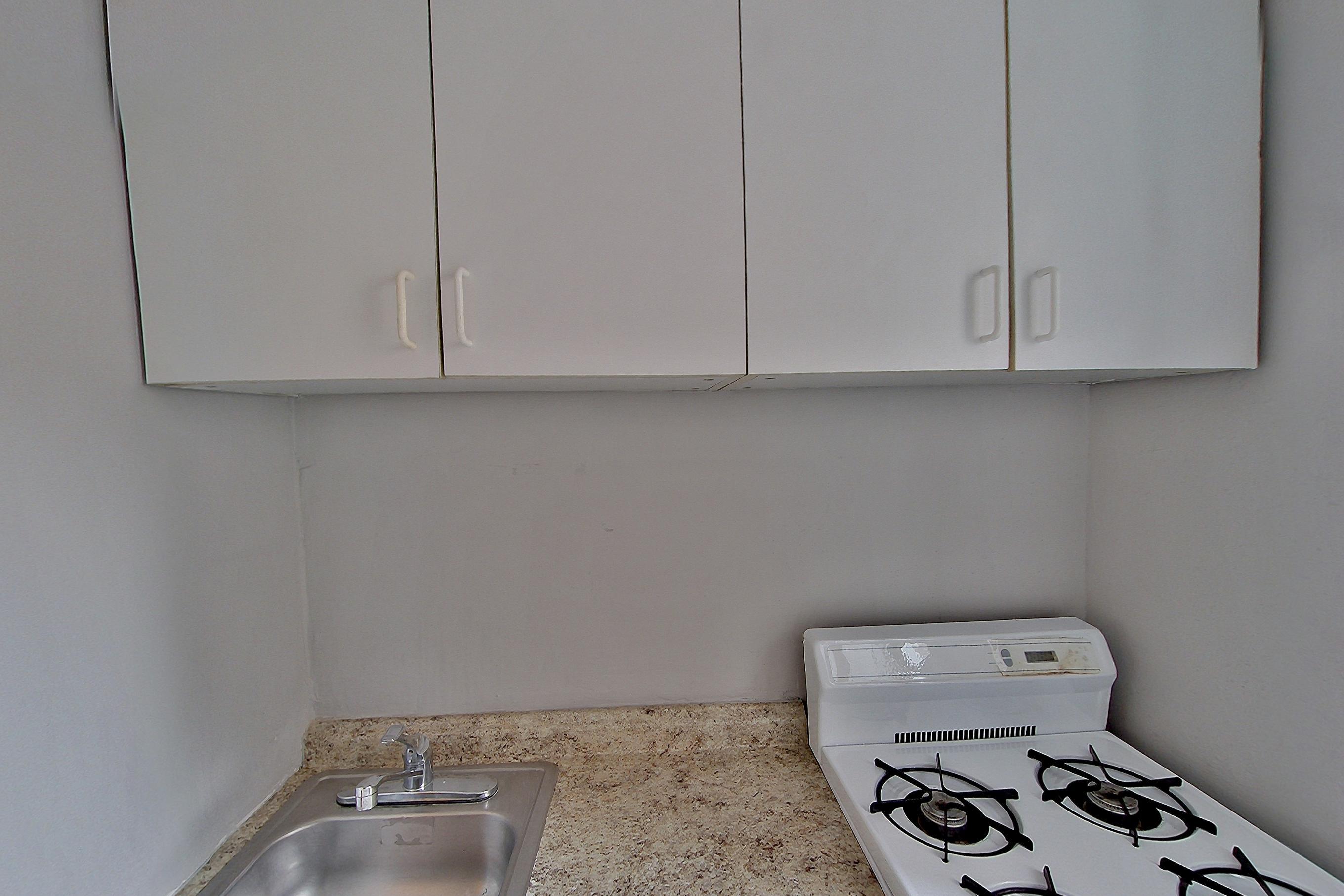 Kitchen with gas range, light stone countertops, oven/range, and white appliances, Apartment 6a at Centennial Properties