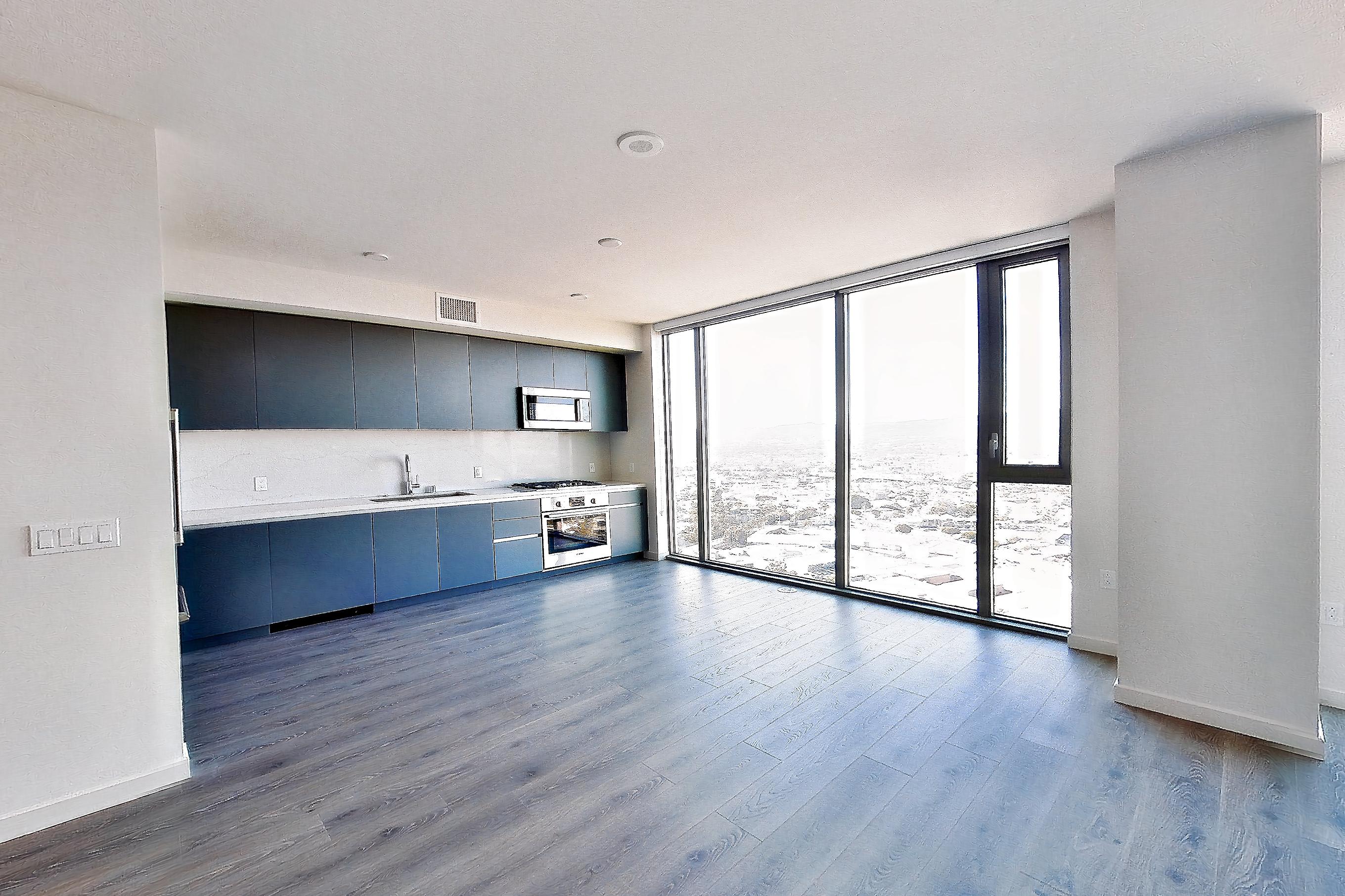 Living area with cooktop, dark wood-finish flooring, gas cooktop, and white appliances, Apartment 2806 at ARQ