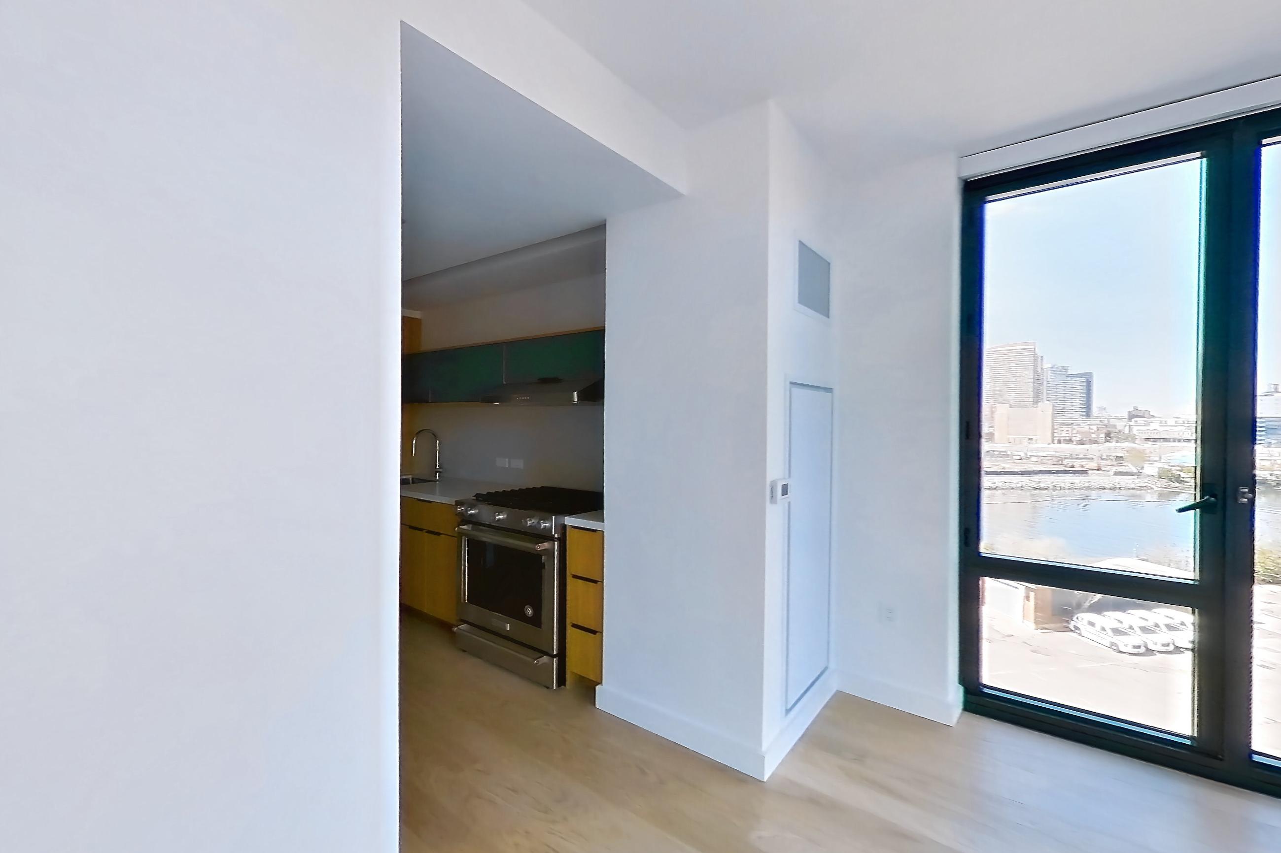 Living space with electric range, oven/range, and stainless steel appliances, Apartment 0-05E at The Bellslip