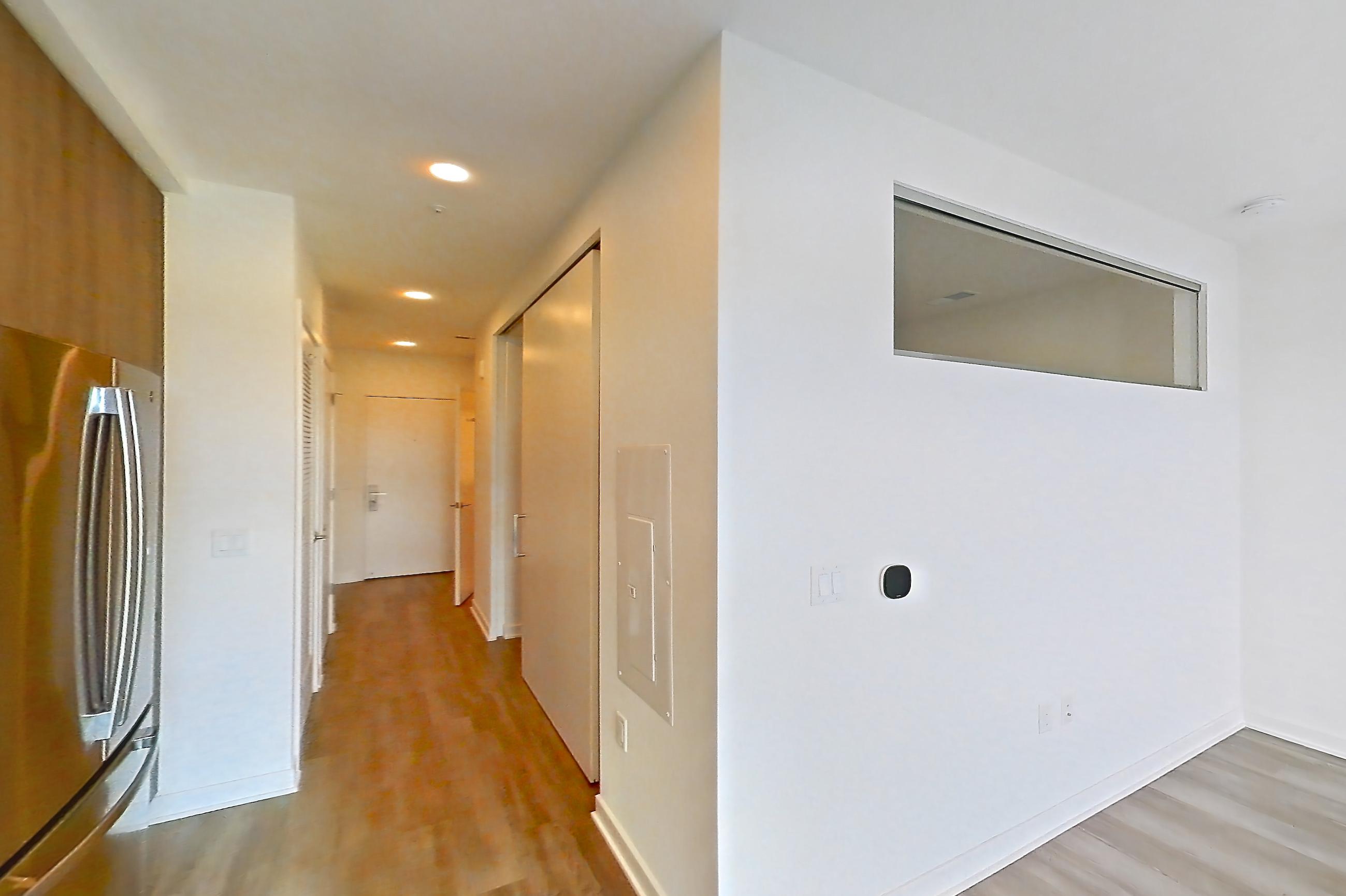Kitchen with dishwasher, electric range, light countertops, light stone countertops, light wood-finish flooring, microwave, oven/range, refrigerator, and stainless steel appliances, Apartment 3703 at Platform (VA)