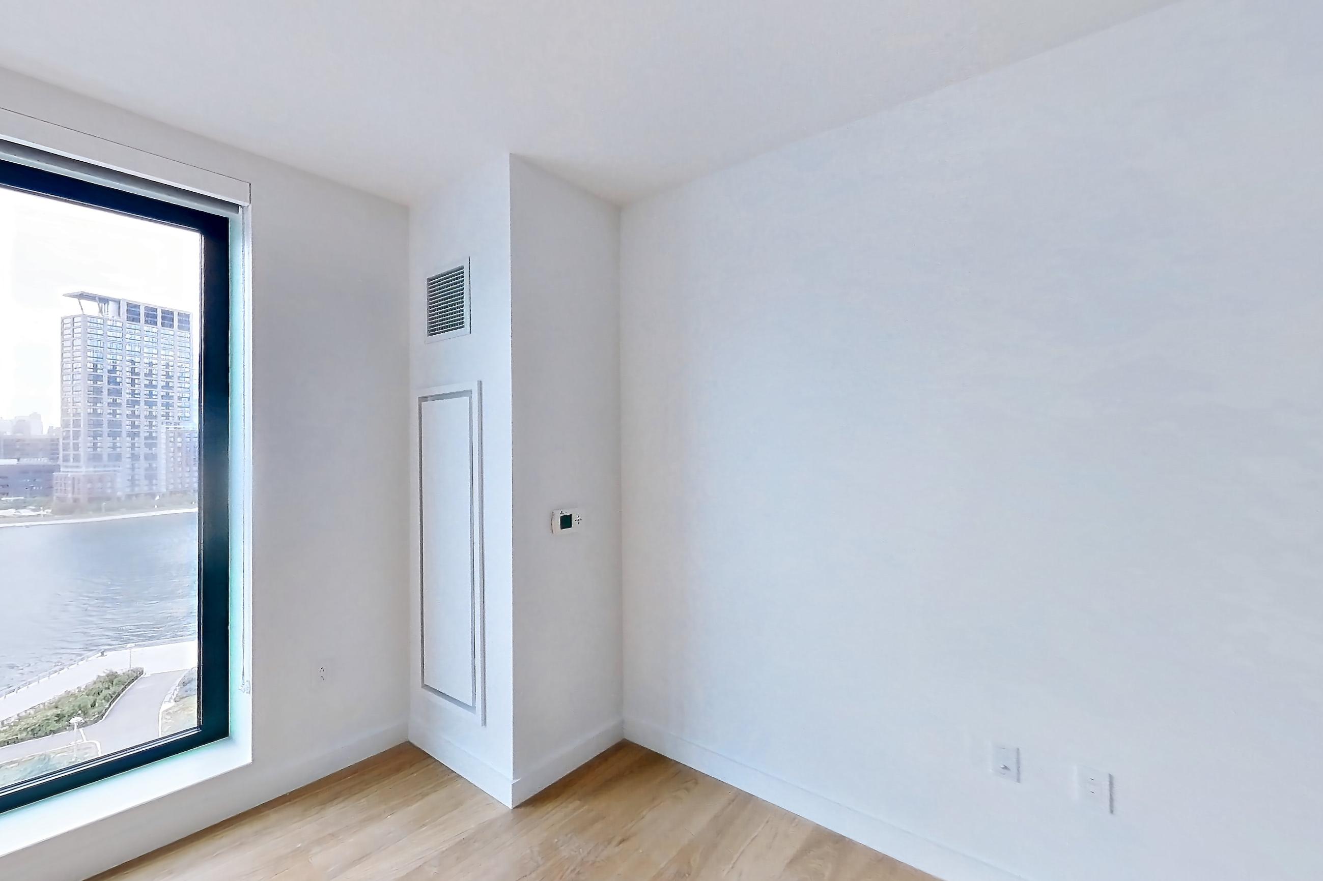 Living room with city view, light wood-finish flooring, and water view, Apartment 1025 at Eagle + West