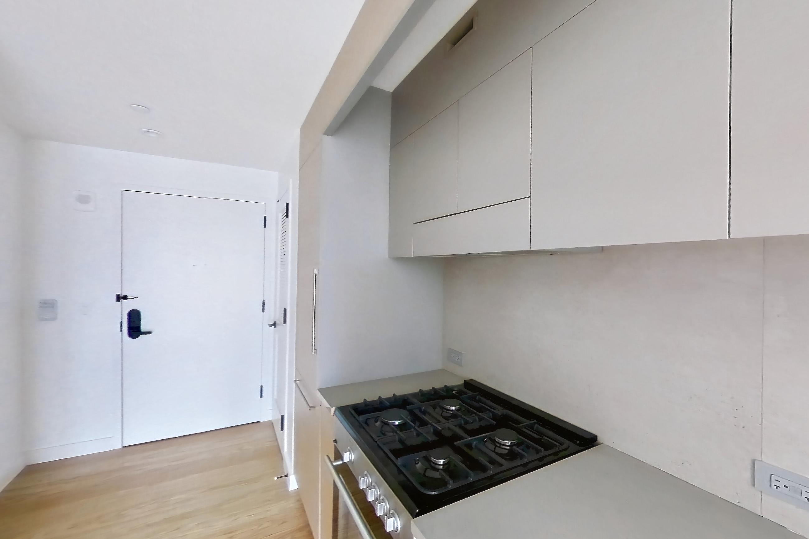 Kitchen with light wood-finish flooring, oven/range, and stainless steel appliances, Apartment 2-1024 at Eagle + West