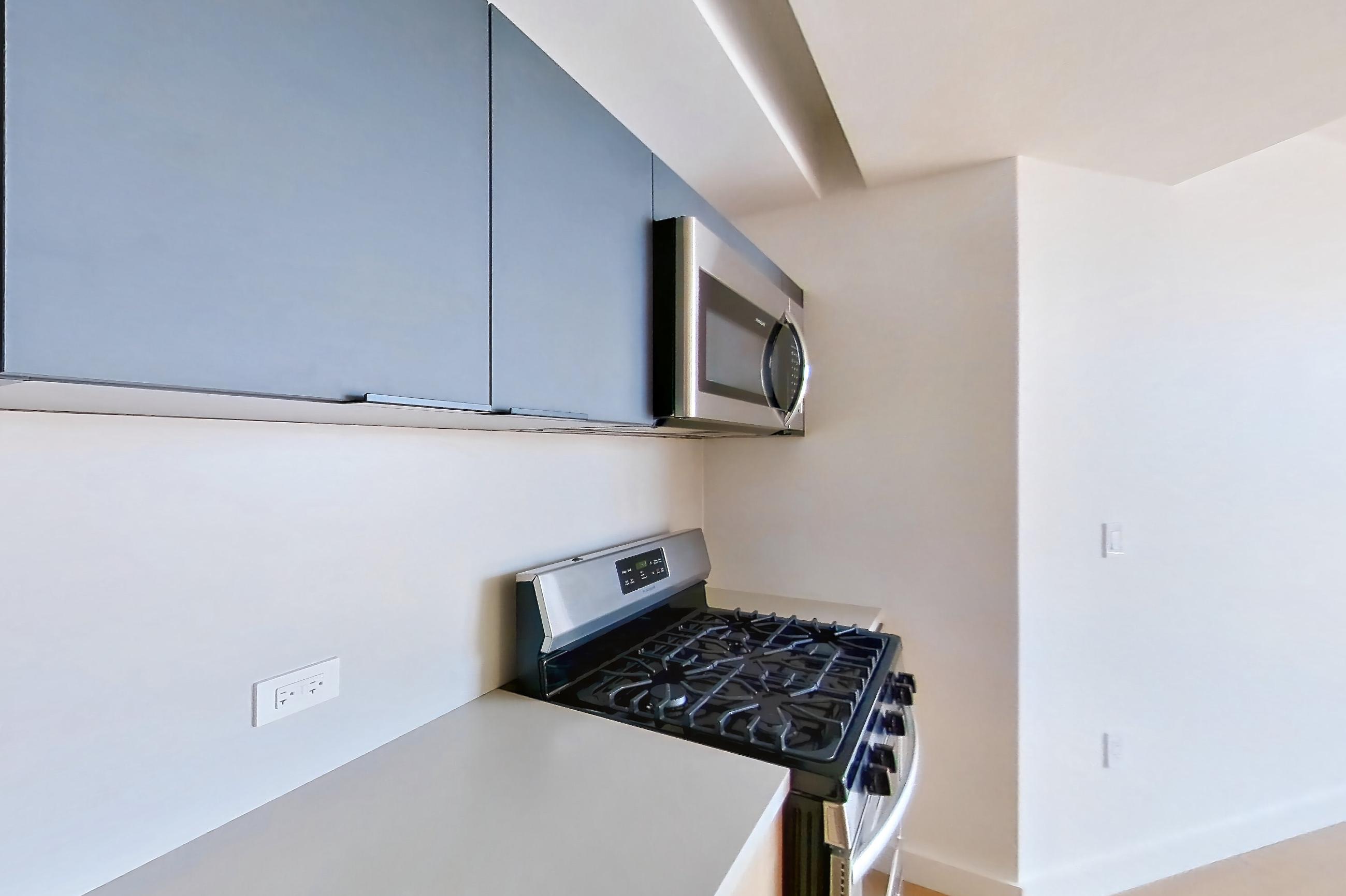 Kitchen with gas range, light wood-finish flooring, oven/range, and stainless steel appliances, Apartment 08P at The Bellslip