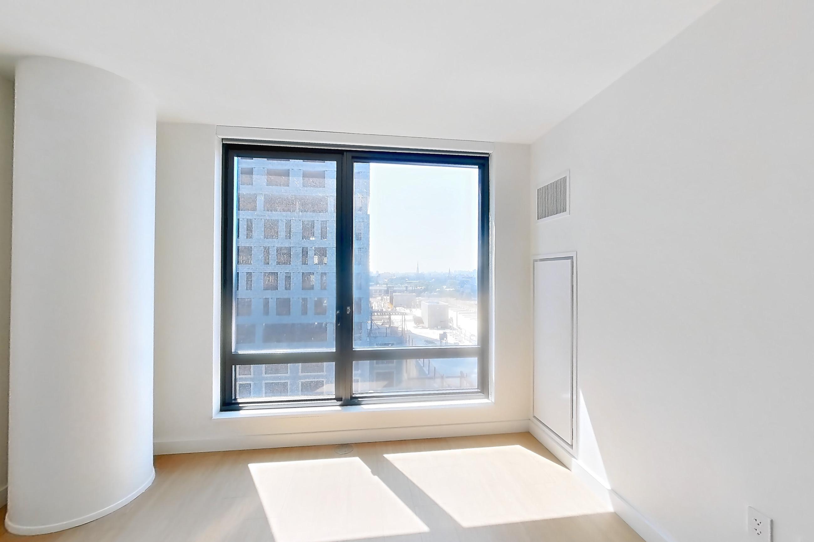 Living room with city view and light wood-finish flooring, Apartment 08P at The Bellslip