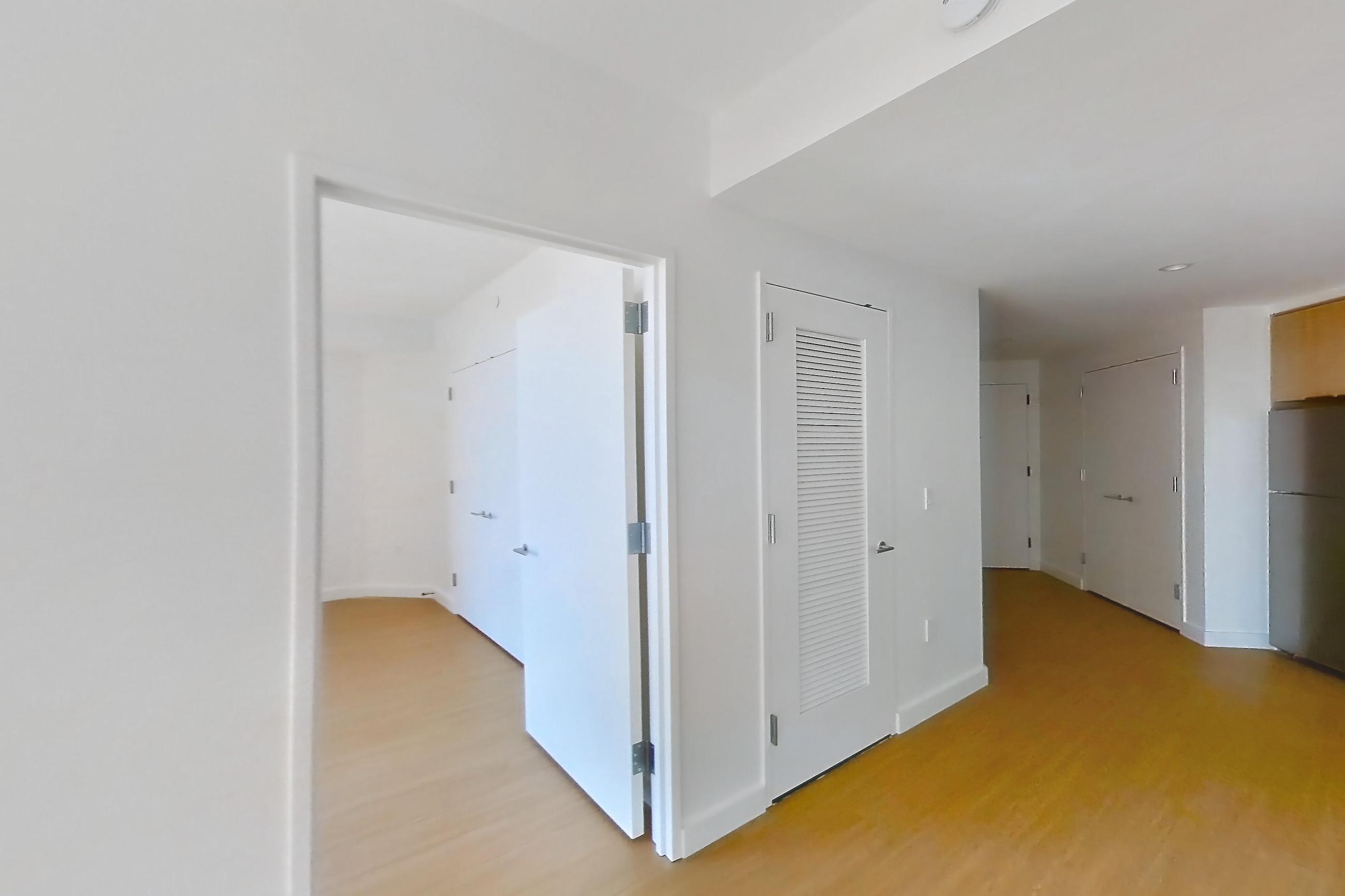 Living room with city view and light wood-finish flooring, Apartment 08P at The Bellslip