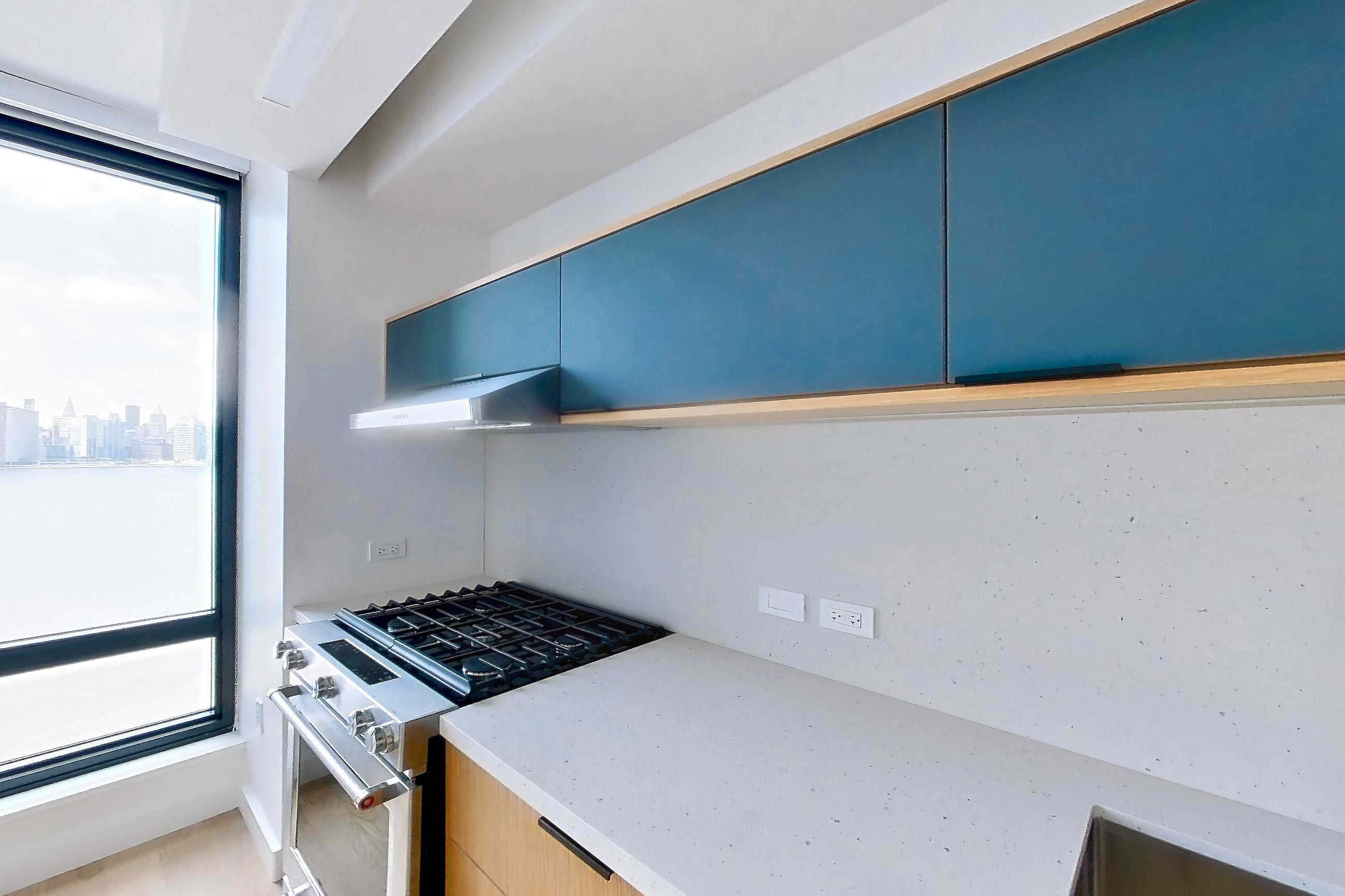 Kitchen with gas range, light stone countertops, and light wood-finish flooring, Apartment 0-08H at The Bellslip
