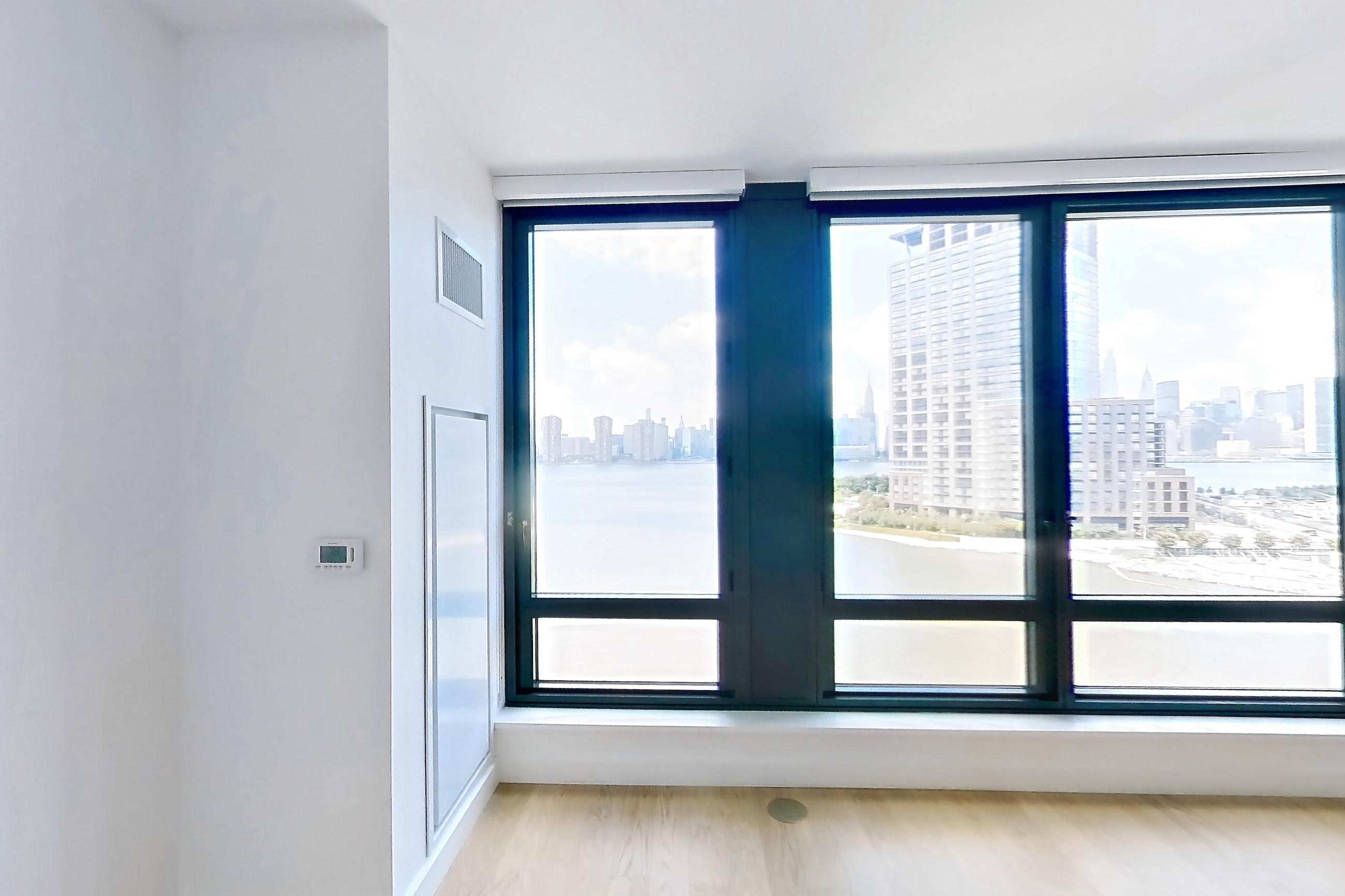 Living room with city view, gas range, light wood-finish flooring, oven/range, and stainless steel appliances, Apartment 0-08H at The Bellslip