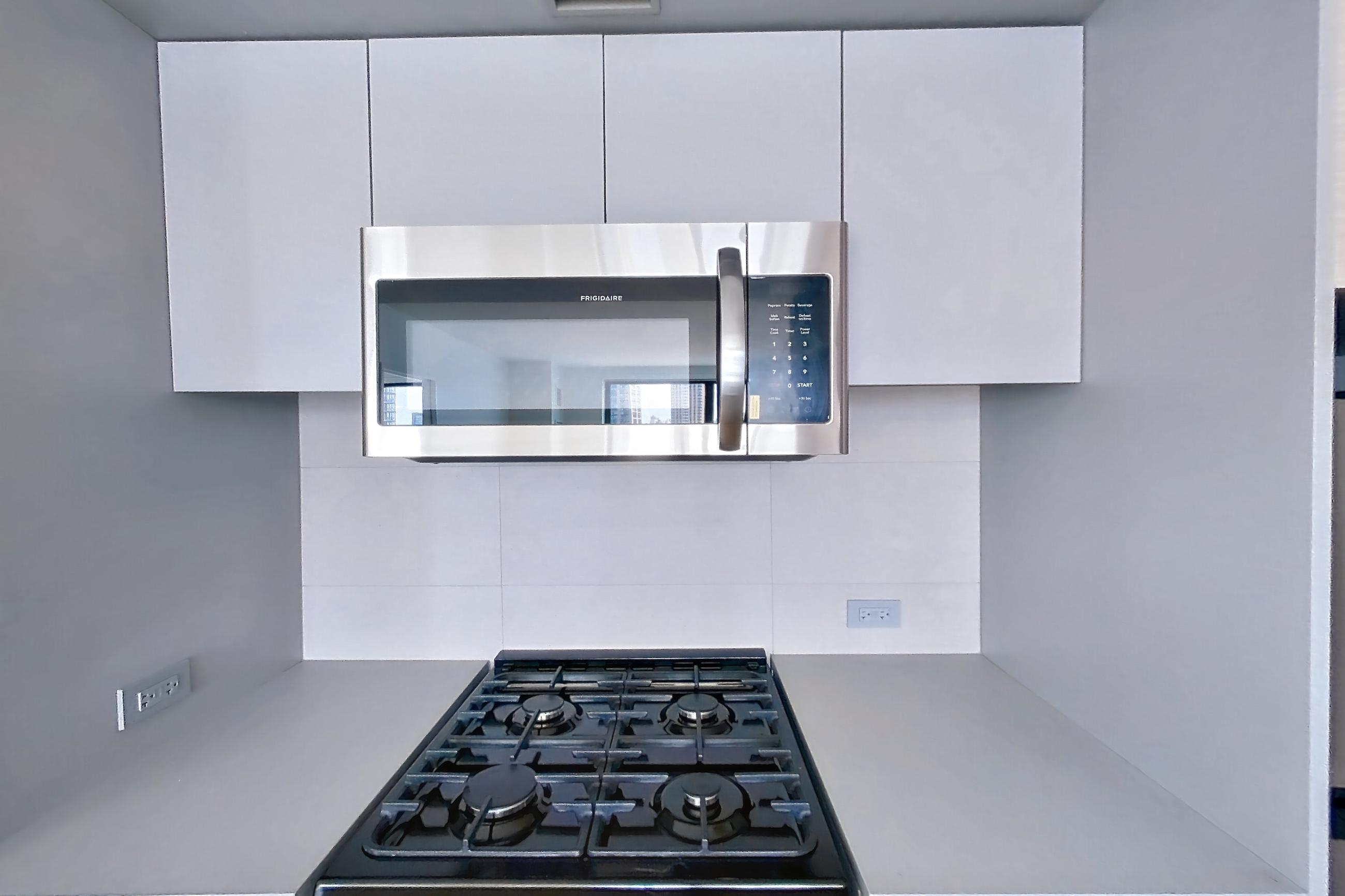 Kitchen with gas range and light wood-finish flooring, Apartment 1025(2) at Eagle + West