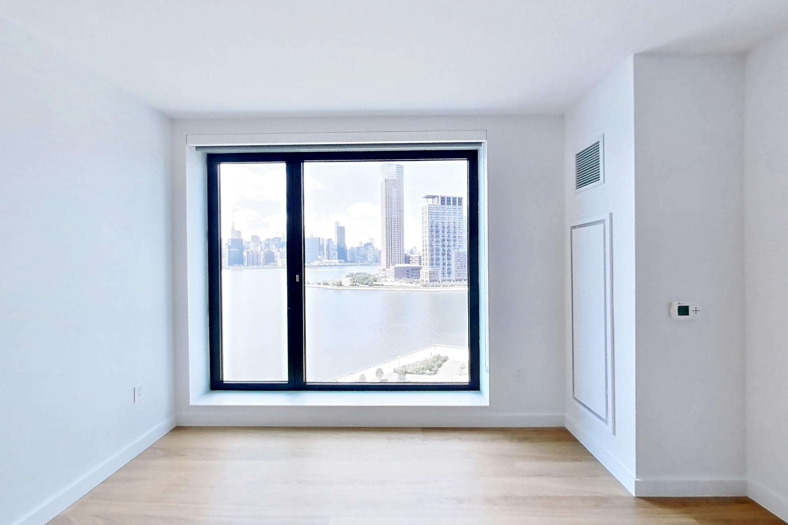Living room with city view, light wood-finish flooring, and skyline view, Apartment 1025(2) at Eagle + West