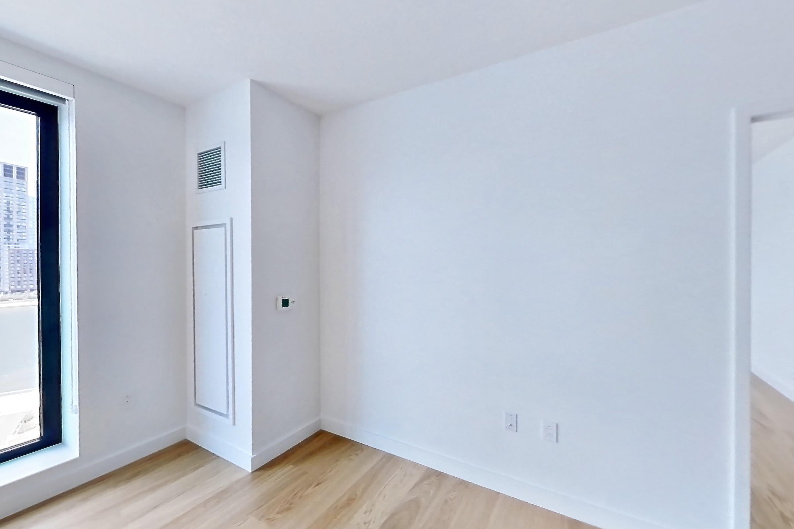 Living room with city view, light wood-finish flooring, and skyline view, Apartment 1025(2) at Eagle + West