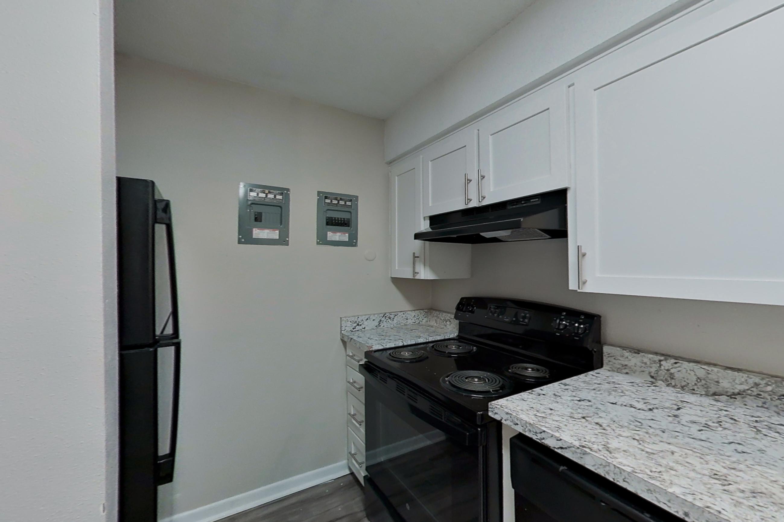 Kitchen with black appliances, electric range, light countertops, and oven/range, Apartment 1530D at The Life at Legacy Fountains