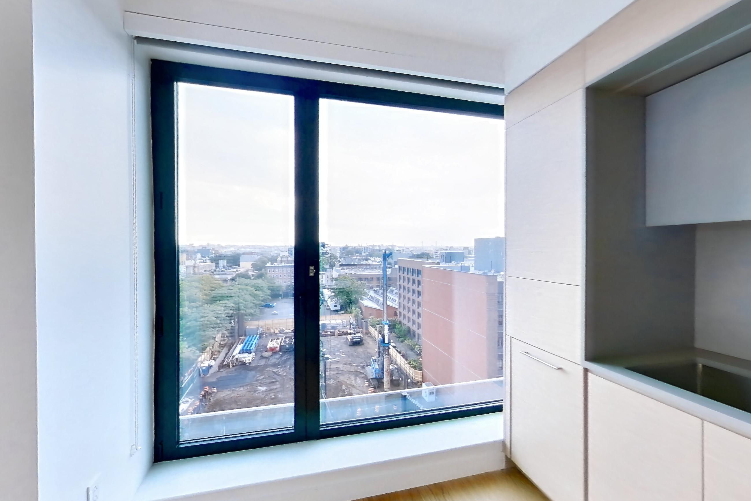Kitchen with city view and light wood-finish flooring, Apartment 2-0822 at Eagle + West