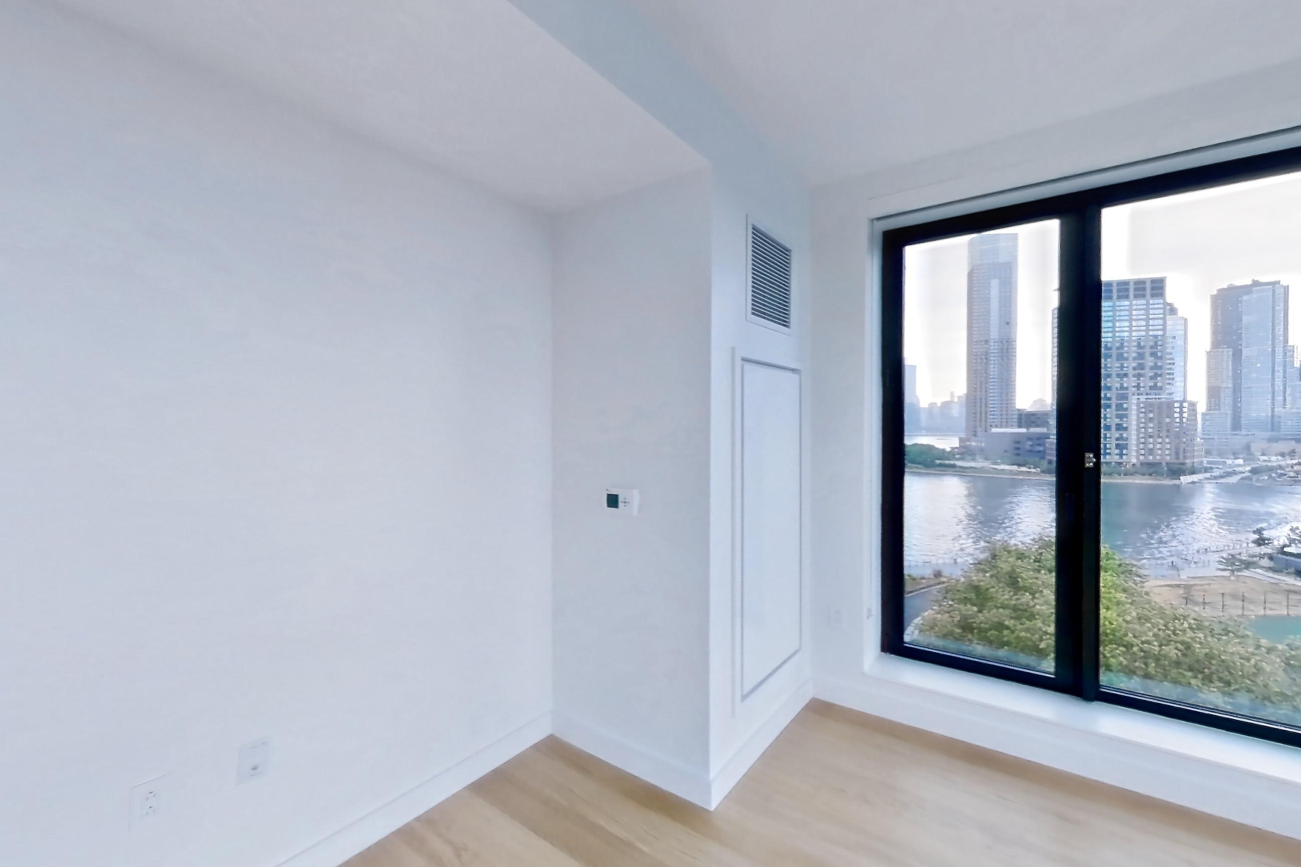 Living room with city view and light wood-finish flooring, Apartment 2-0822 at Eagle + West