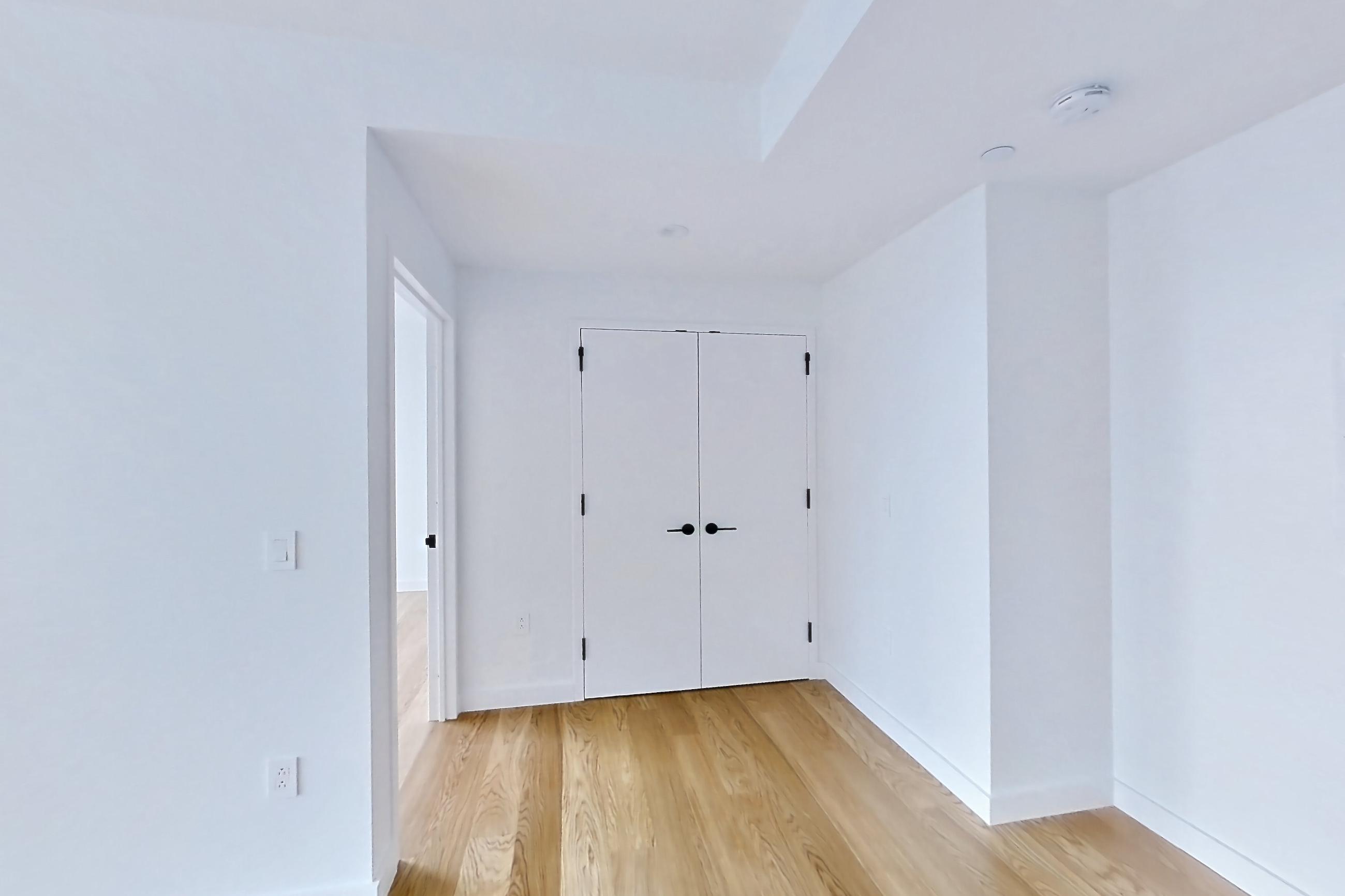 Living room with electric range, light wood-finish flooring, oven/range, and stainless steel appliances, Apartment 0937 at Eagle + West