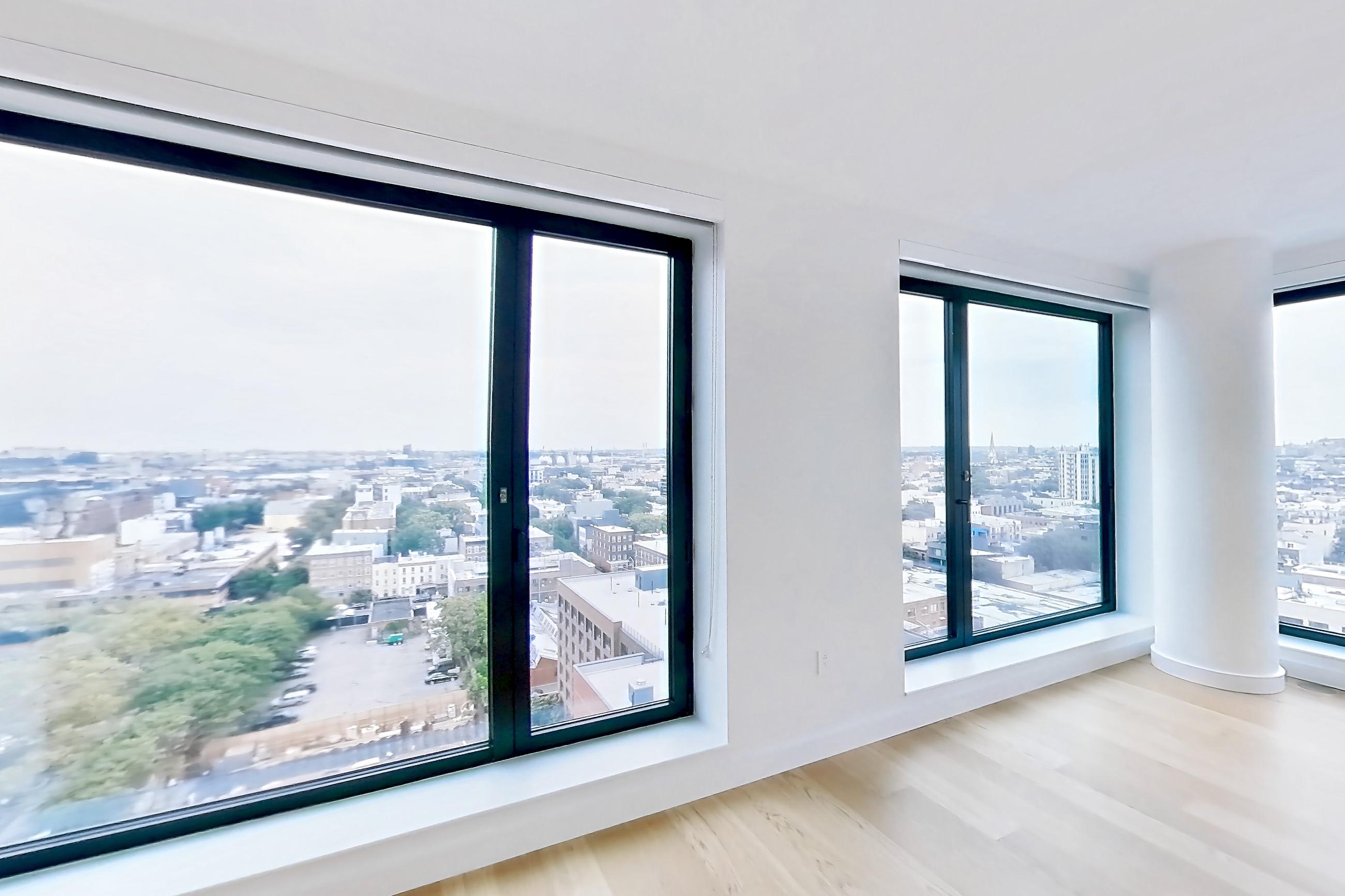 Living room with city view and light wood-finish flooring, Apartment 2-1521 at Eagle + West