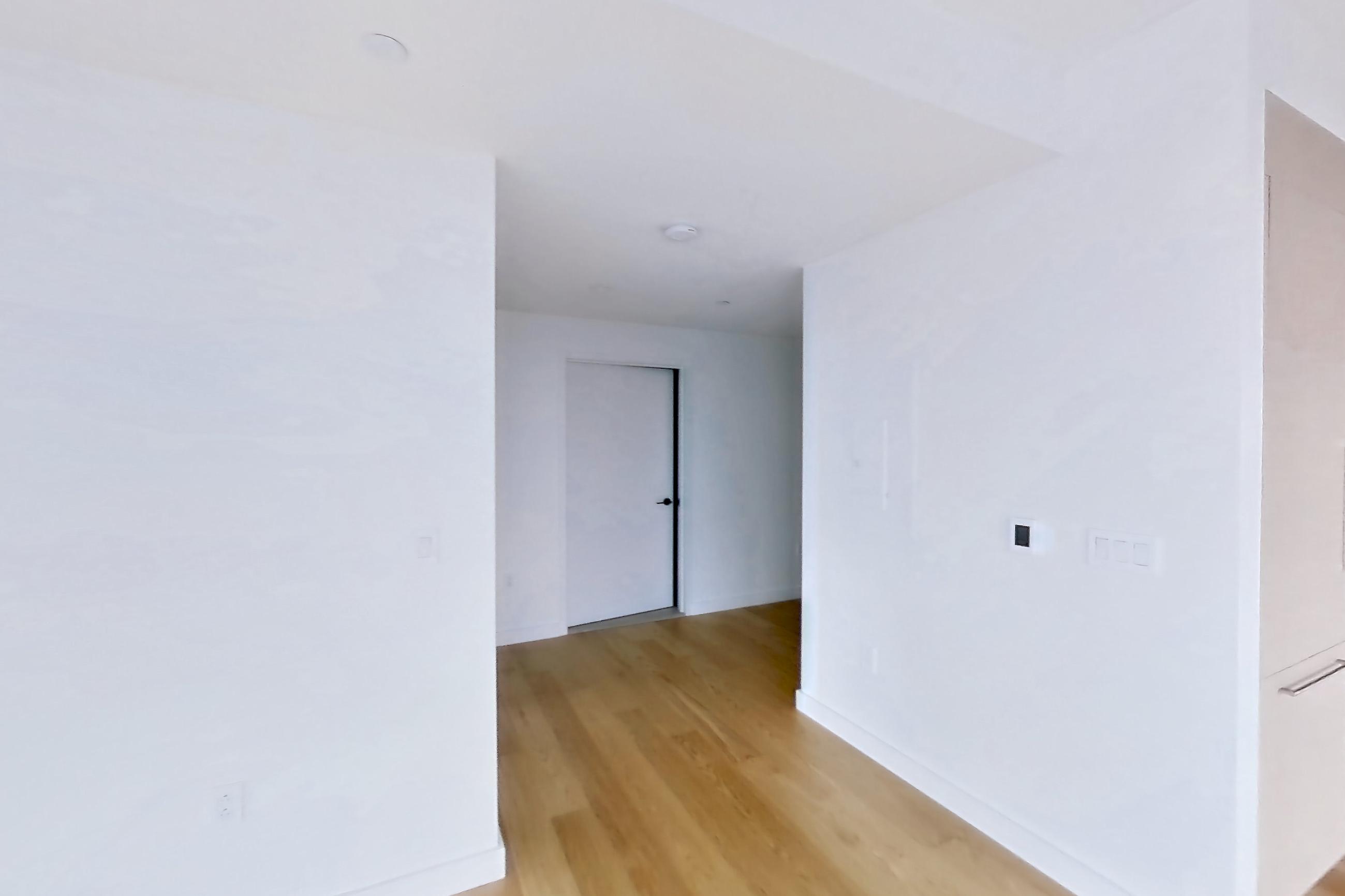 Living room with city view and light wood-finish flooring, Apartment 2-1521 at Eagle + West