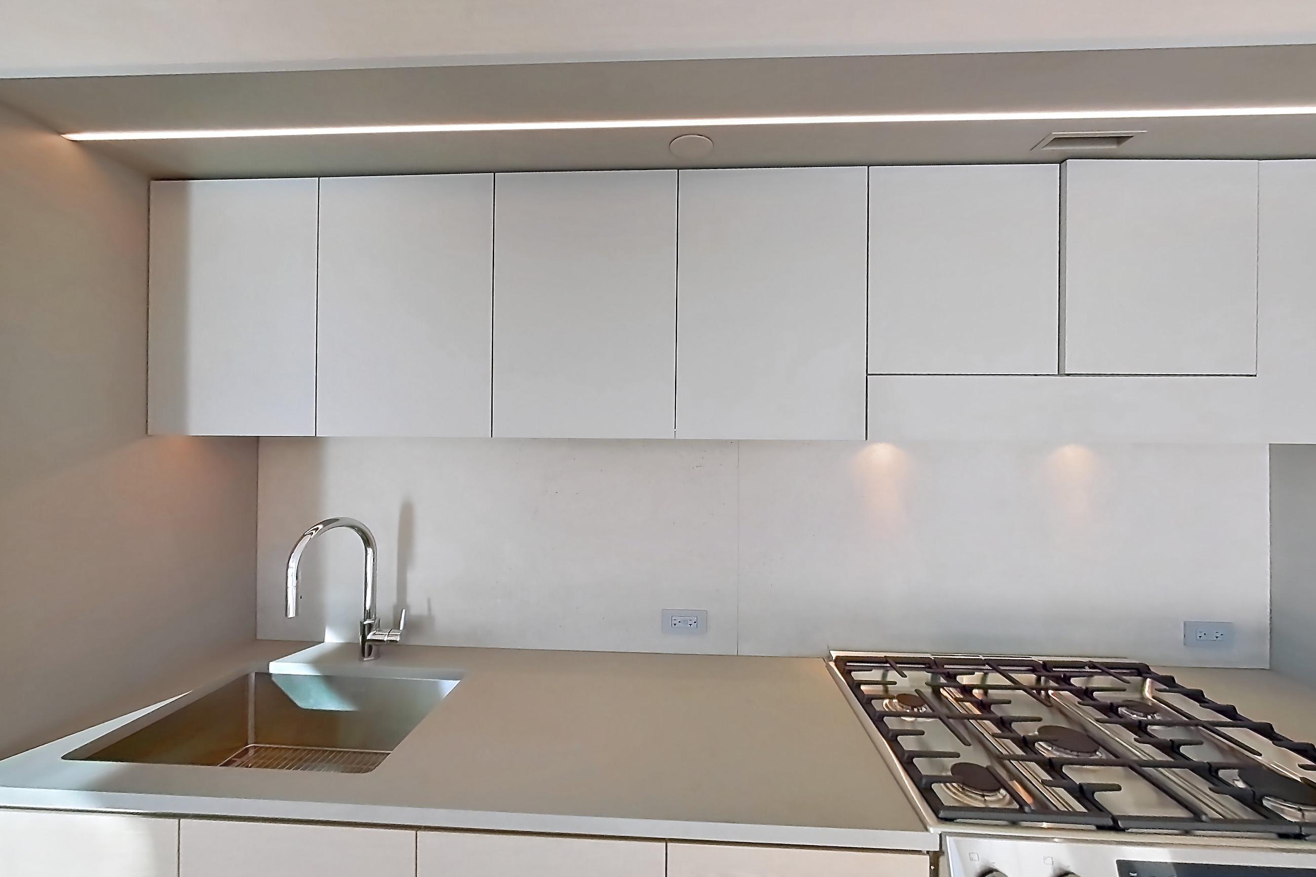 Kitchen with city view, gas range, light wood-finish flooring, oven/range, skyline view, and stainless steel appliances, Apartment 2-1526 at Eagle + West