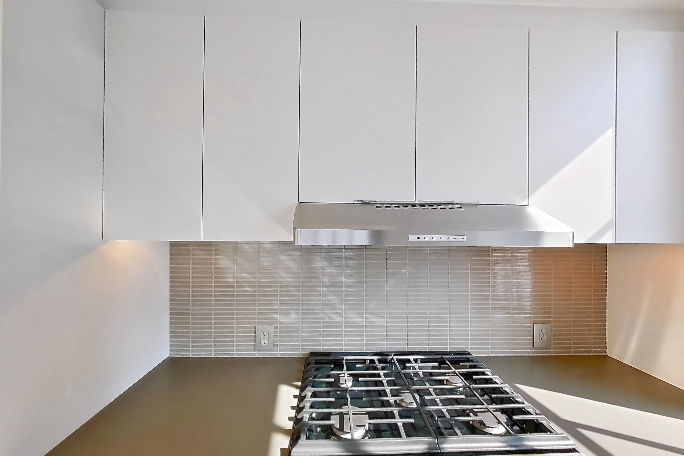Kitchen with gas range, light wood-finish flooring, oven/range, and stainless steel appliances, Apartment 0-28C at One Blue Slip