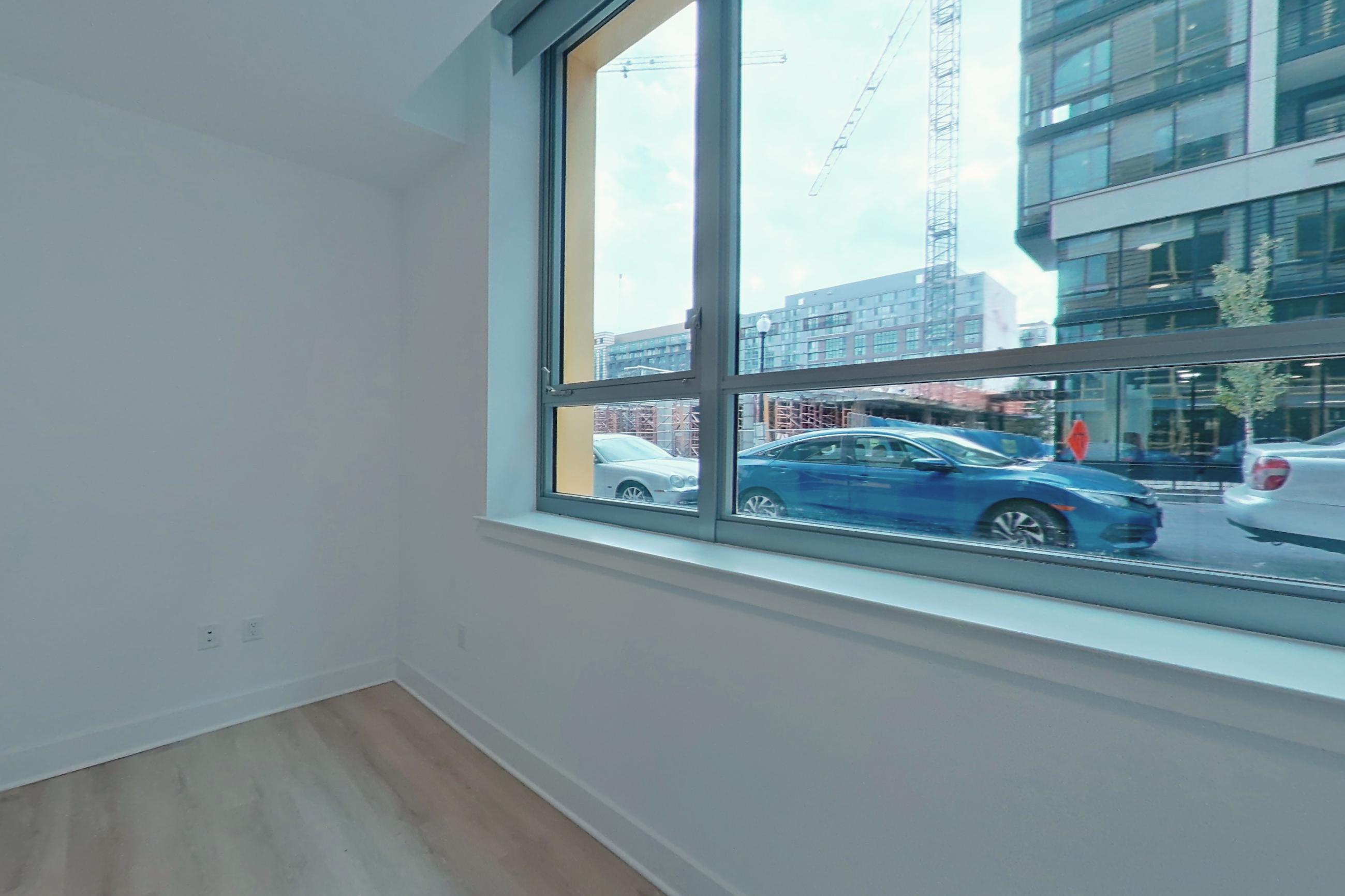 Living space with city view and light wood-finish flooring, Apartment 111 at SoNYa