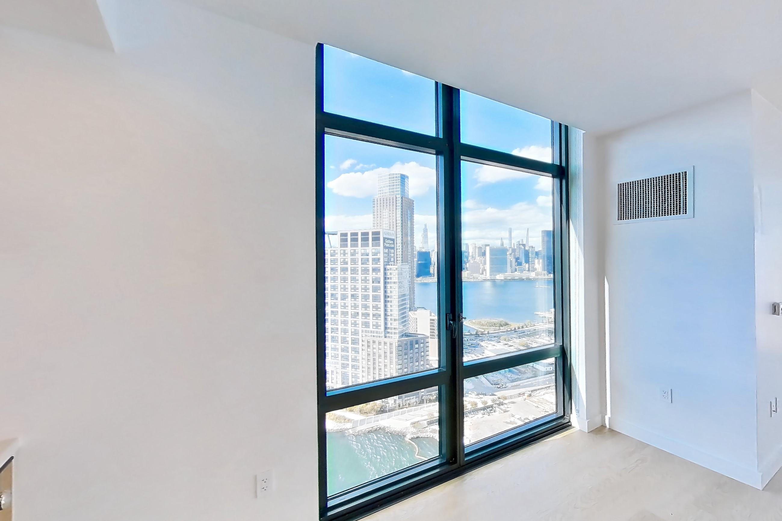 Kitchen with city view, gas range, light stone countertops, light wood-finish flooring, oven/range, and stainless steel appliances, Apartment 0-PHF at The Bellslip