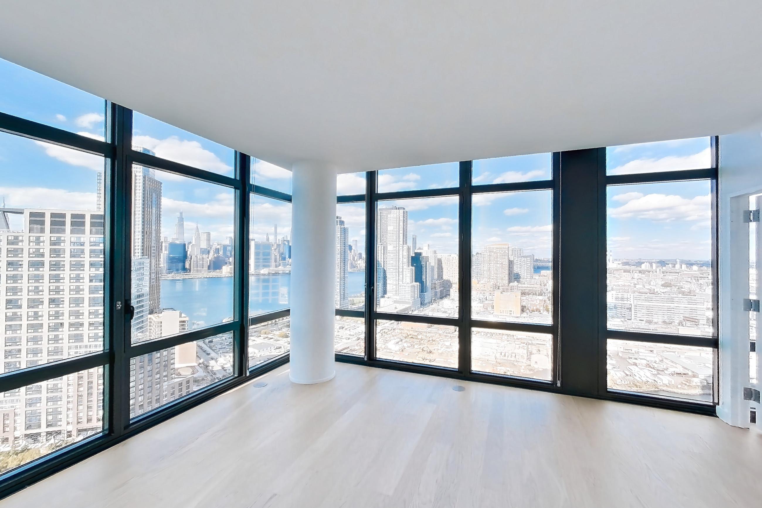 Living room with city view, gas range, light wood-finish flooring, oven/range, and stainless steel appliances, Apartment 0-PHF at The Bellslip