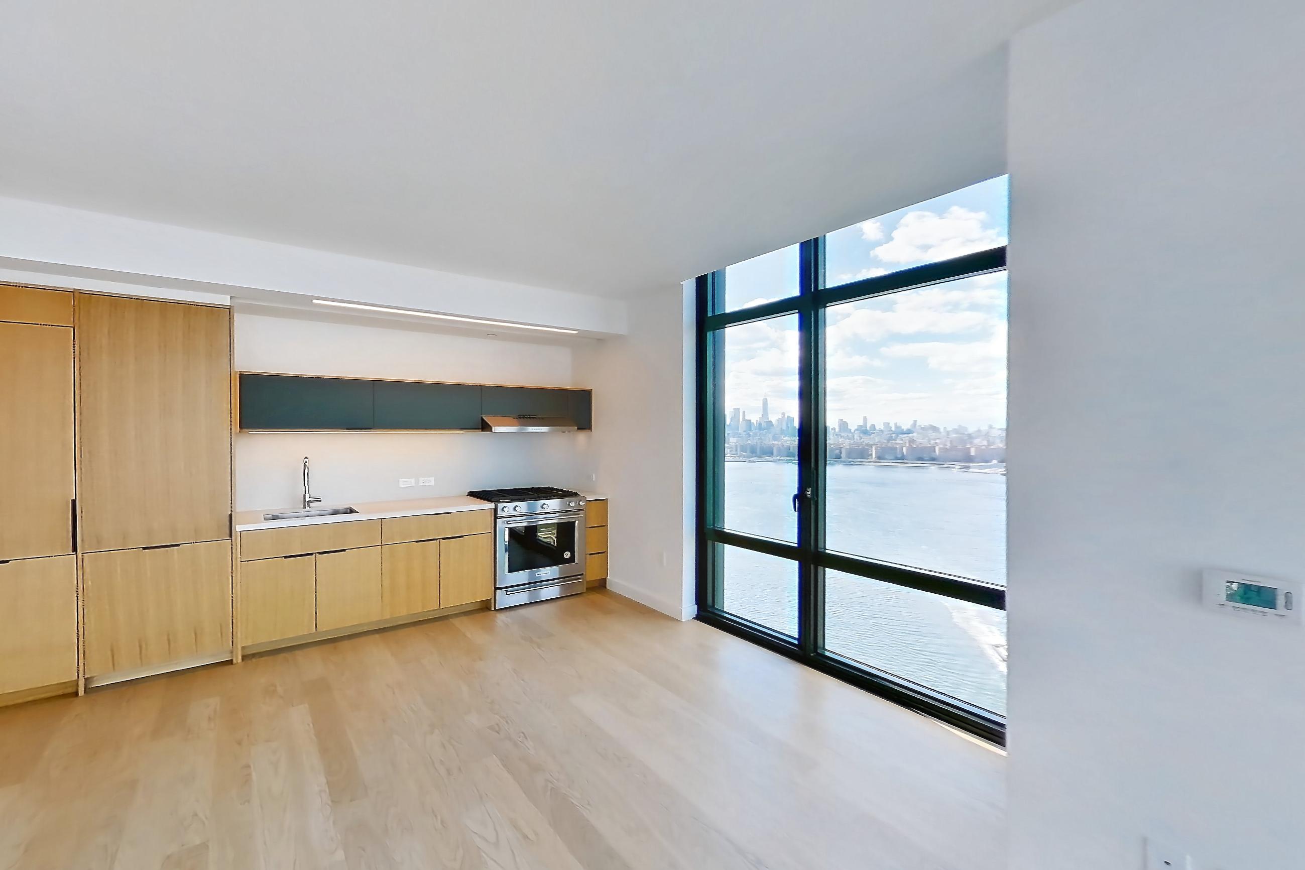 Living room with city view, gas range, light wood-finish flooring, oven/range, and stainless steel appliances, Apartment 0-PHF at The Bellslip