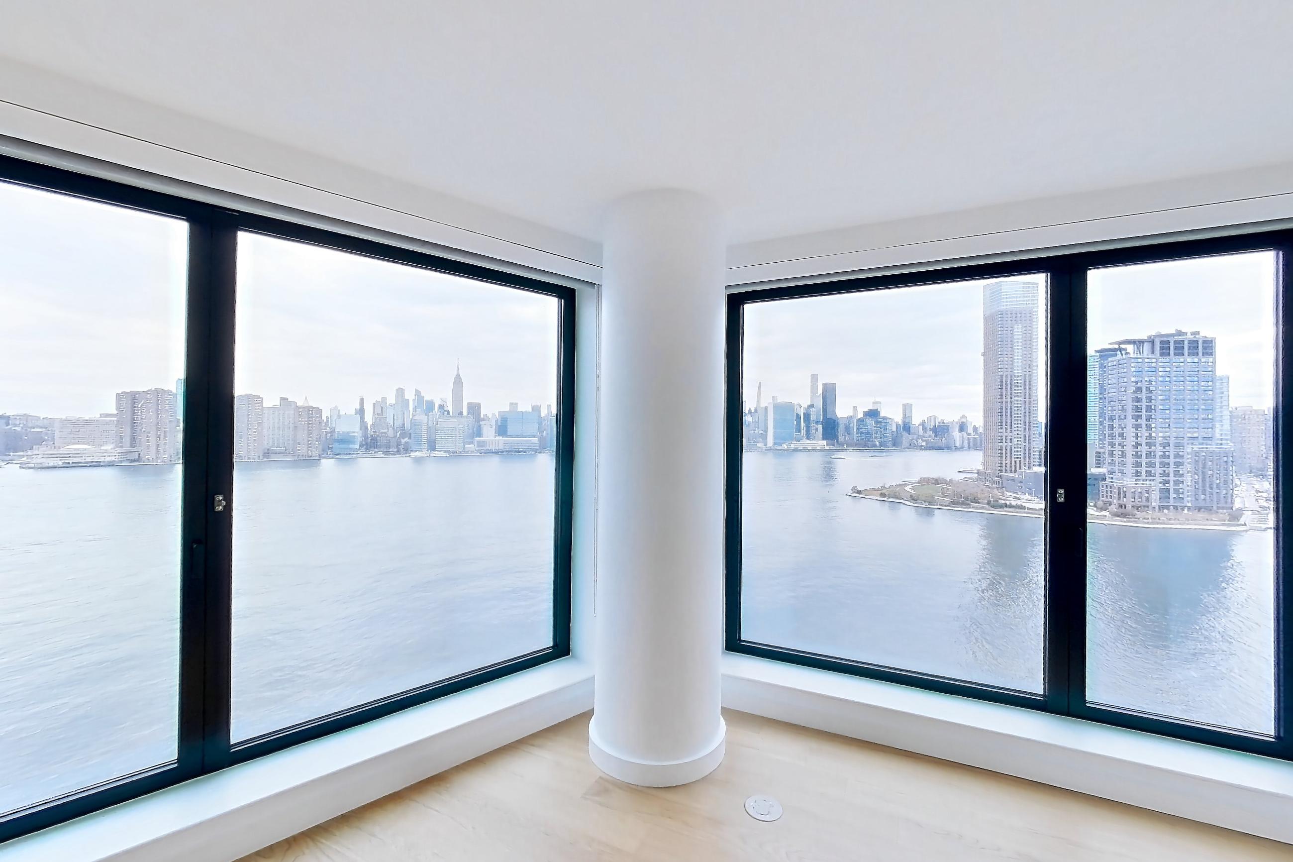 Living room with city view, light wood-finish flooring, and water view, Apartment 1-1604 at Eagle + West