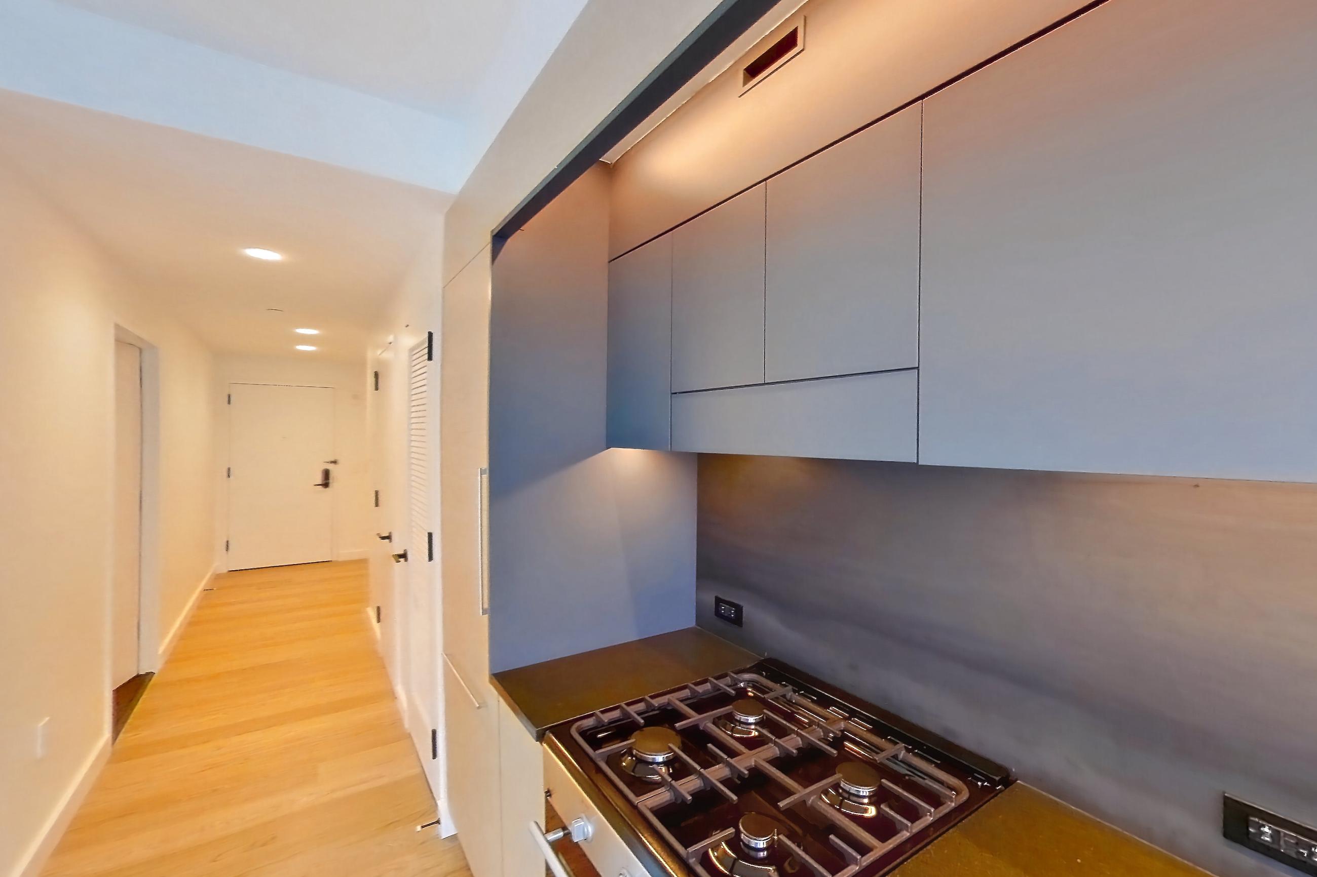 Kitchen with gas cooktop and light wood-finish flooring, Apartment 1-1907 at Eagle + West