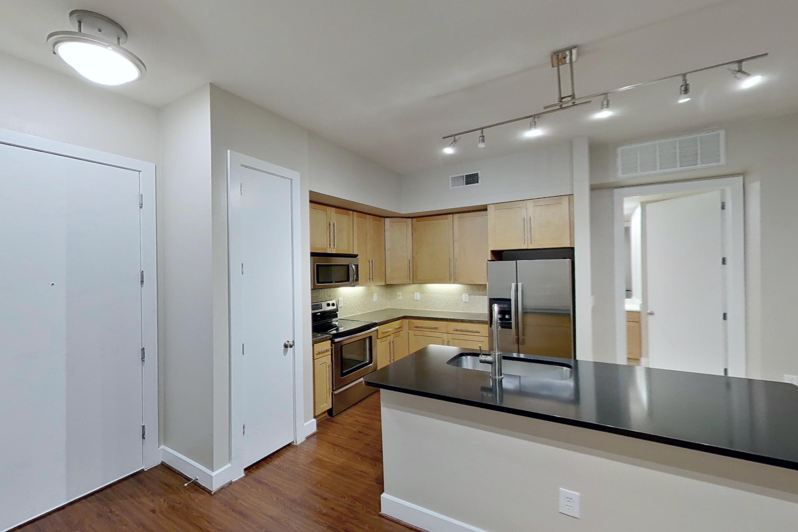 Living space with dark countertops, dark wood-finish flooring, electric range, kitchen island, oven/range, refrigerator, stainless steel appliances, and water & ice dispenser, Apartment 160 at Domain at CityCentre