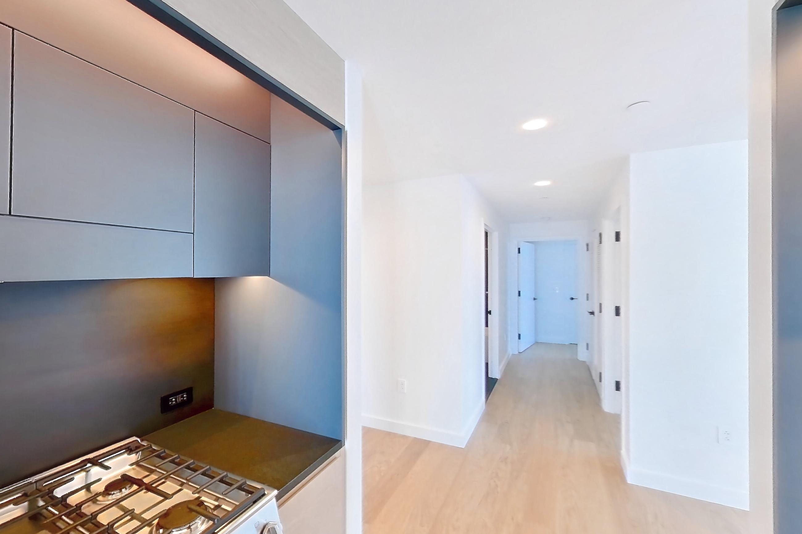 Kitchen with gas range, light wood-finish flooring, oven/range, and stainless steel appliances, Apartment 1-2607 at Eagle + West