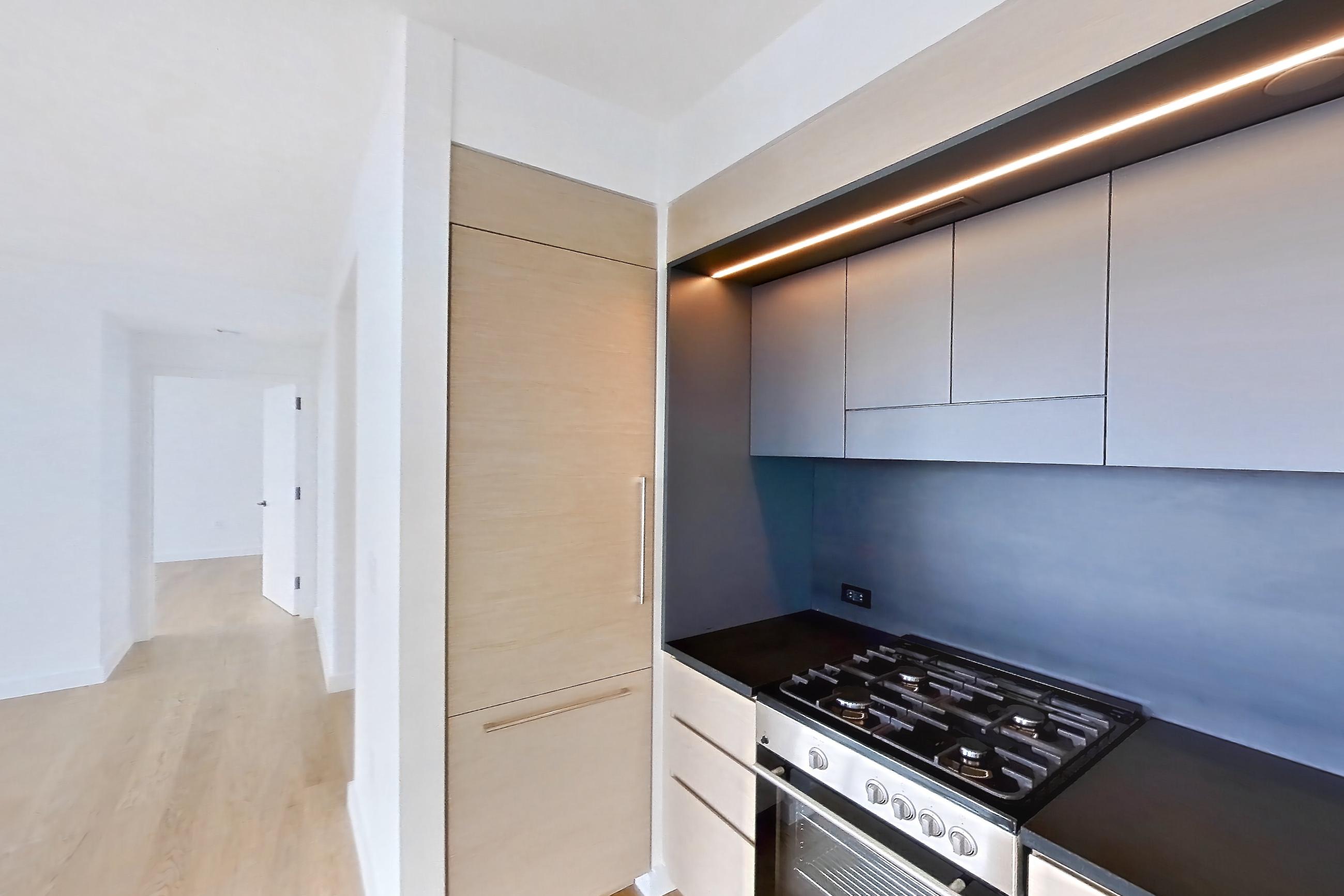 Kitchen with gas range, light wood-finish flooring, oven/range, and stainless steel appliances, Apartment 1-2501 at Eagle + West
