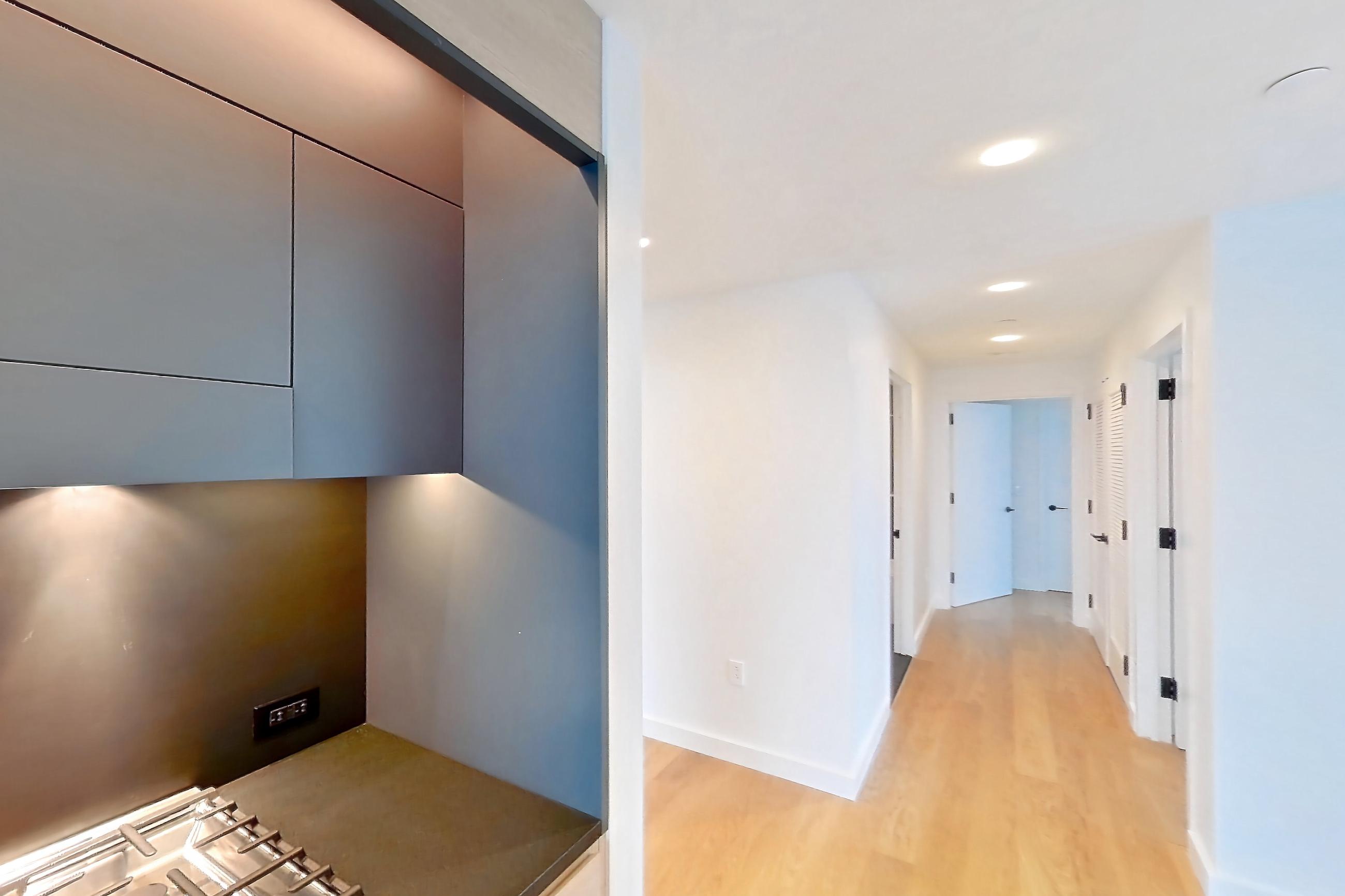 Kitchen with gas range, light wood-finish flooring, oven/range, and stainless steel appliances, Apartment 1-2407 at Eagle + West