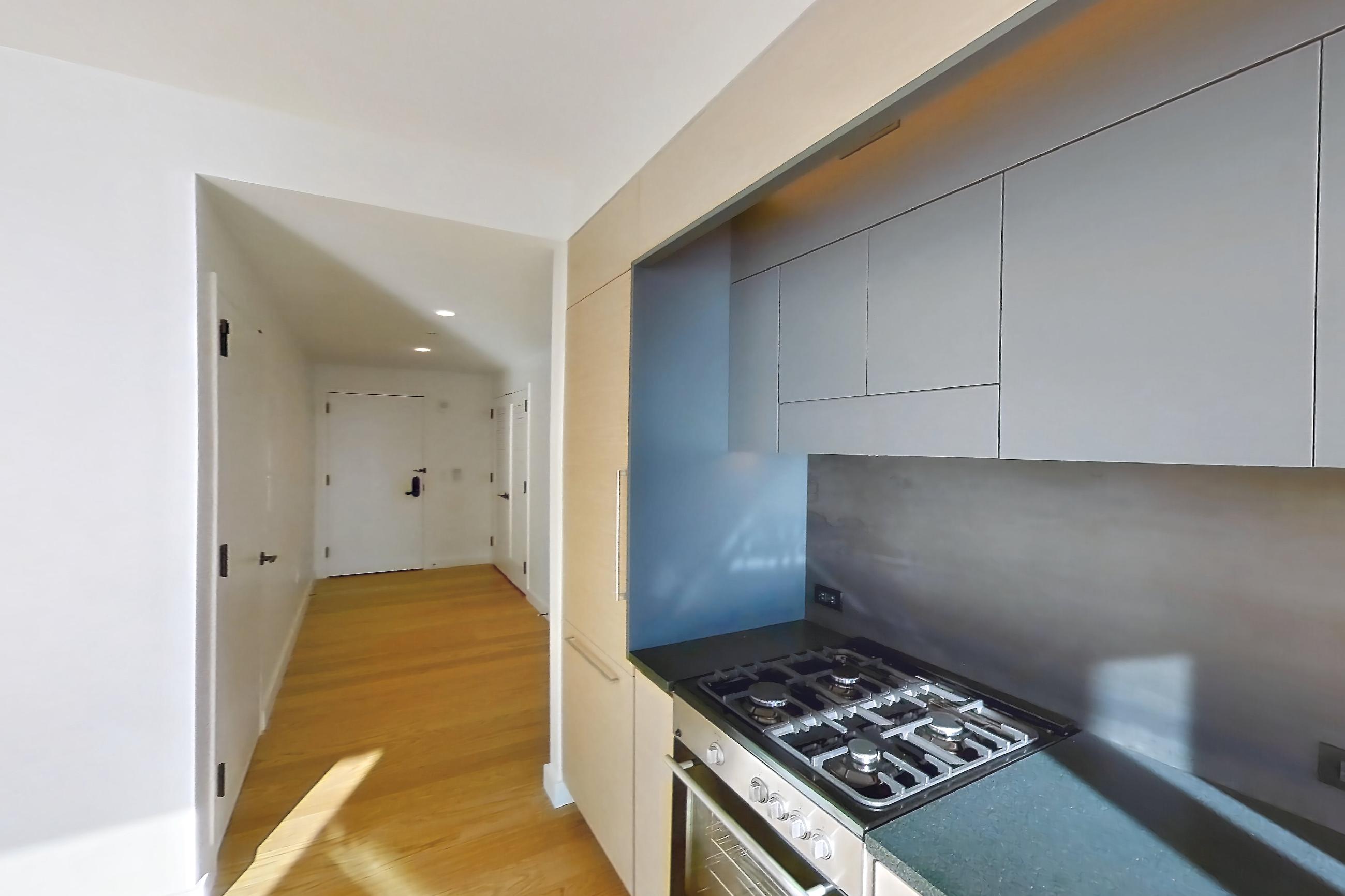Kitchen with gas range, light wood-finish flooring, oven/range, and stainless steel appliances, Apartment 1-2001 at Eagle + West