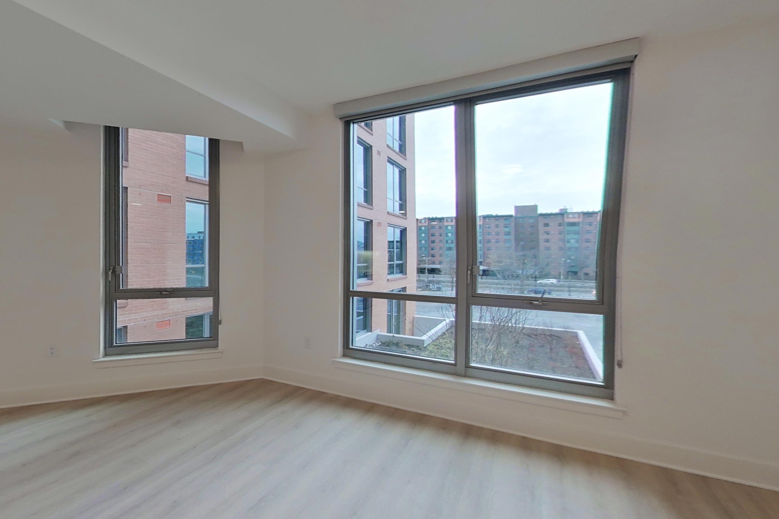 Living room with city view and light wood-finish flooring, Apartment 420 at SoNYa