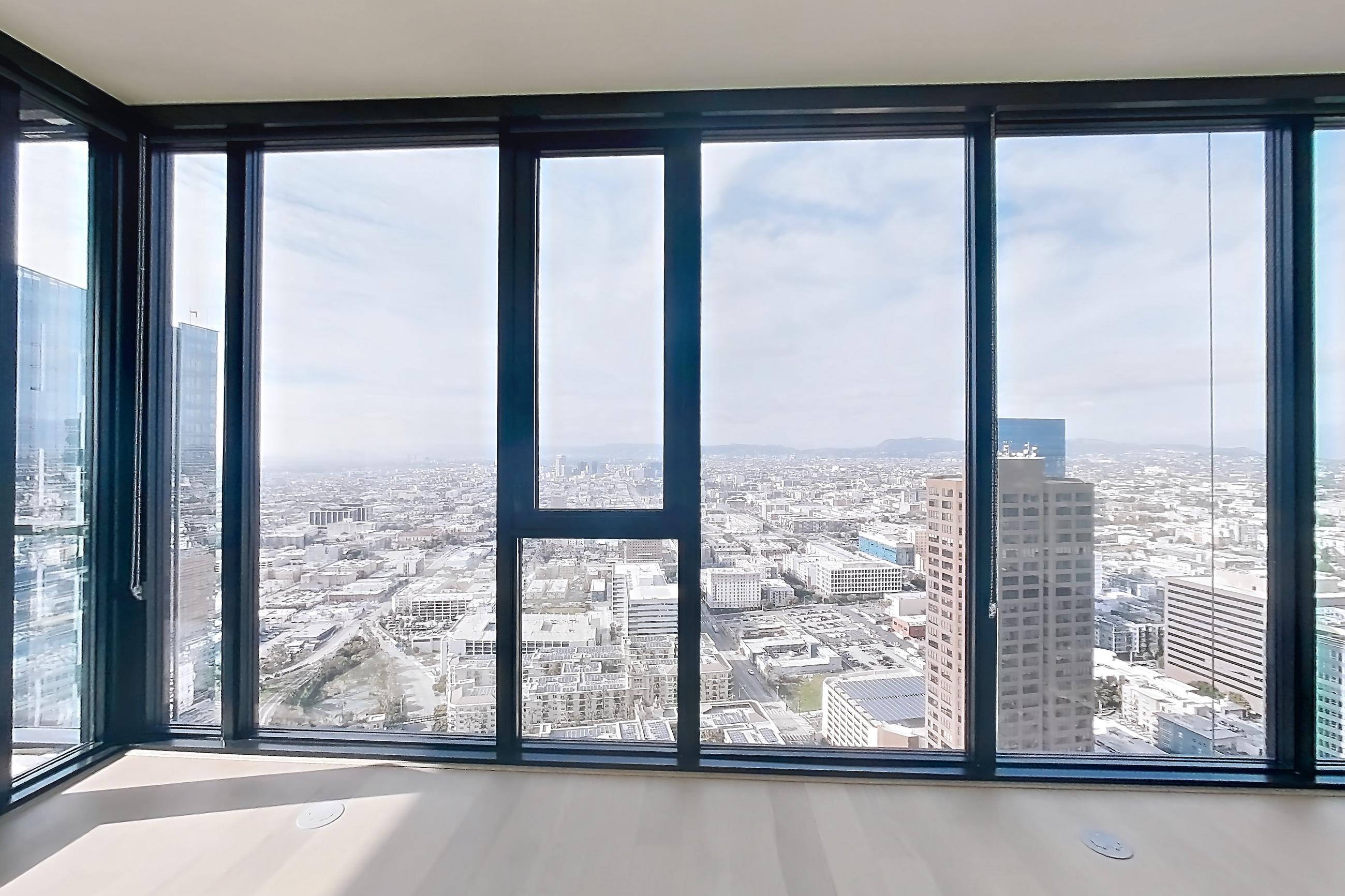 Living area with city view and light wood-finish flooring, Apartment 4801 - VIEW at Beaudry